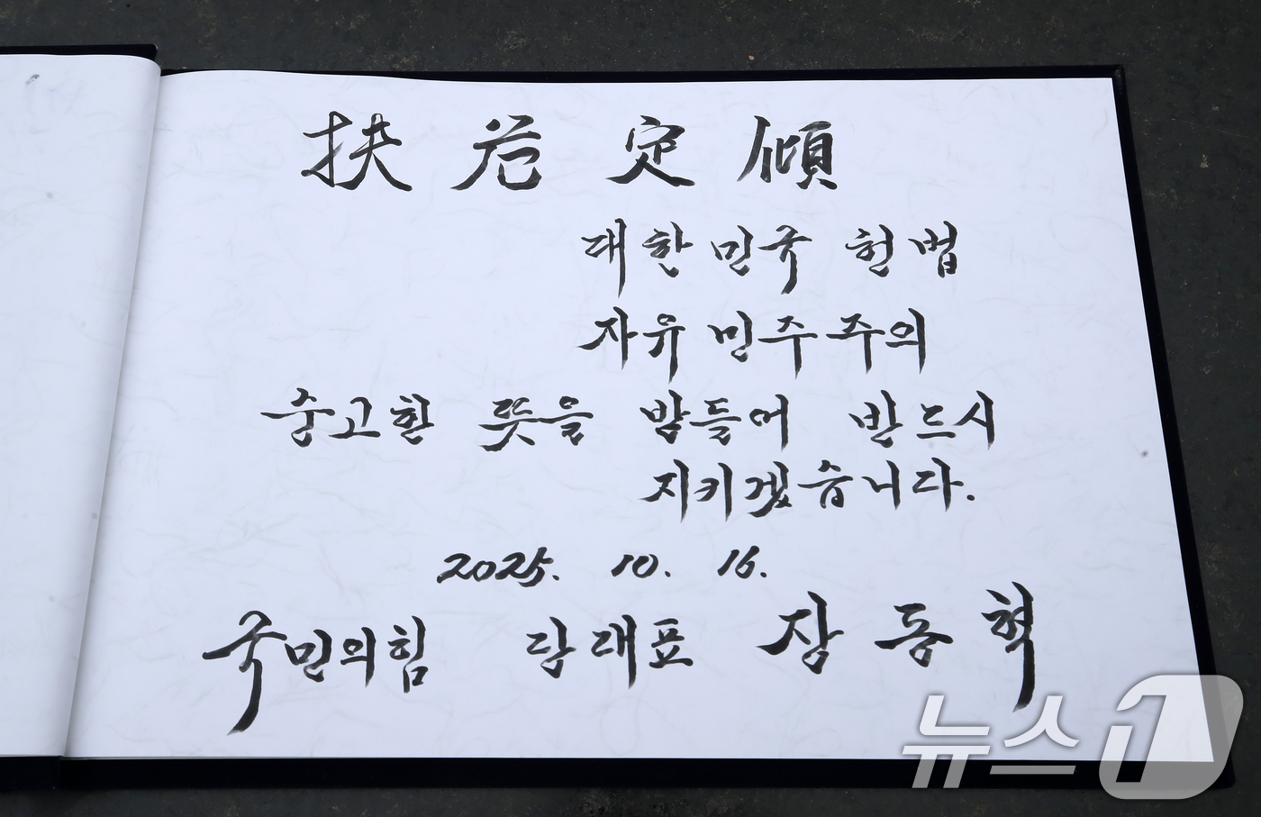 (창원=뉴스1) 윤일지 기자 = 장동혁 국민의힘 대표가 16일 오전 경남 창원 마산회원구 국립3·15민주묘지를 참배한 후 작성한 방명록.장 대표는 "대한민국 헌법 자유민주주의 숭고 …