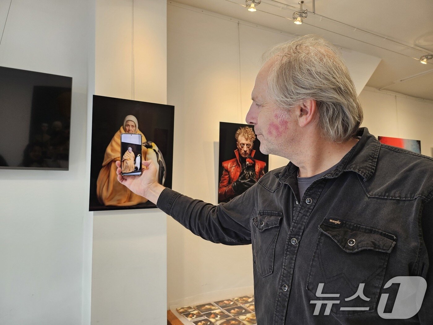본문 이미지 - 지난 9월 네덜란드 암스테르담 &#39;데드엔드&#40;Dead End&#41; 갤러리&#39;에서 만난 콘스탄트 브링크만&#40;Constant Brinkman&#41; 관장이 스마트폰 카메라를 활용해 움직이는 작품을 보여주고 있다. 2025.10.16/뉴스1 ⓒ News1 이수민 기자