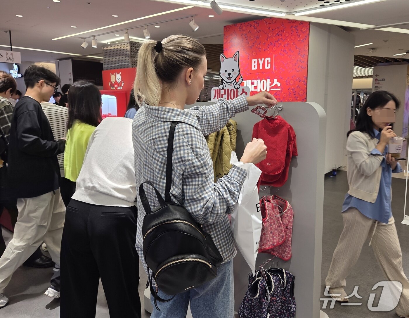본문 이미지 - 개리야스 팝업 스토어에서 반려견용 빨간내복을 살펴보는 외국인 고객 ⓒ 뉴스1 한송아 기자