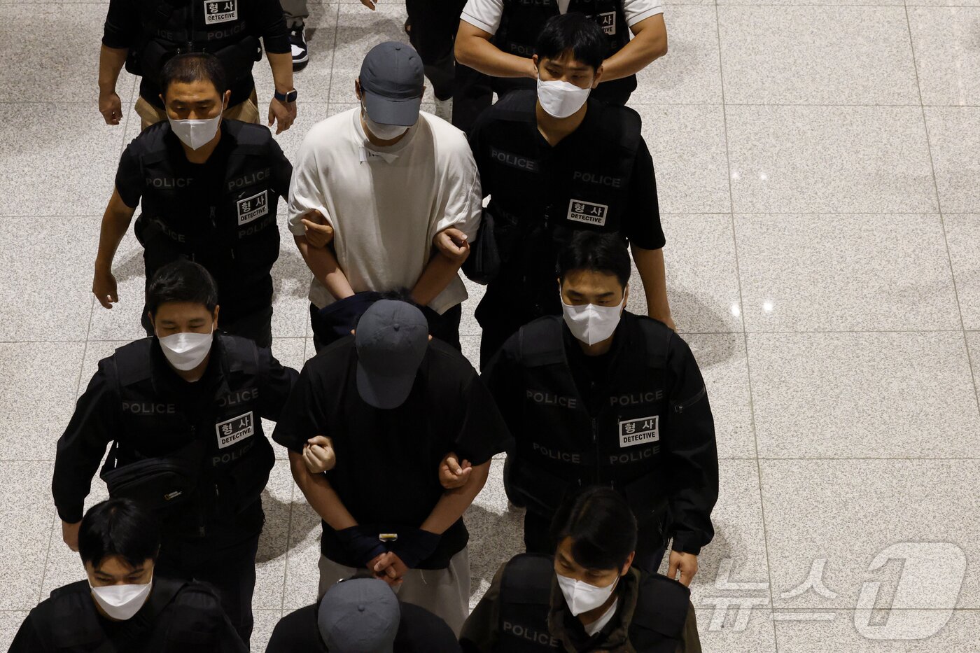 본문 이미지 - 캄보디아 당국의 범죄단지 단속으로 적발돼 구금됐던 한국인들이 18일 오전 인천국제공항 2터미널을 통해 송환되고 있다. 이번 송환 대상자들은 이른바 &#39;웬치&#39;로 불리는 캄보디아 범죄단지에서 보이스피싱이나 로맨스 스캠&#40;사기&#41; 등 범죄에 가담한 혐의를 받고 있다. 이들은 호송 차량 23대 등을 타고 충남경찰청 등 6개 관할 경찰관서로 압송된다. &#40;공동취재&#41; 2025.10.18/뉴스1 ⓒ News1 박지혜 기자