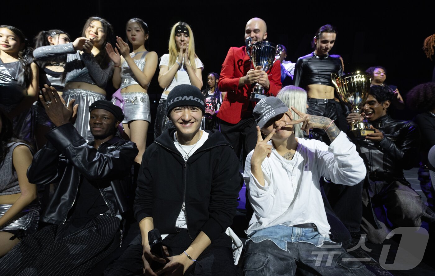 본문 이미지 - 18일&#40;현지시간&#41; 프랑스 파리 북서쪽 인근 클리시홀에서 열린 ‘글로벌 K-팝 컴피티션 파리 2025’&#40;Global K-POP Competition Paris 2025&#41;에서 참가자들이 심사위원으로 참석한 위댐보이즈&#40;We Dem Boyz&#41;의 바타와 카멜과 함께 기념 촬영을 하고 있다. 2025.10.19/뉴스1 ⓒ News1 이준성 기자