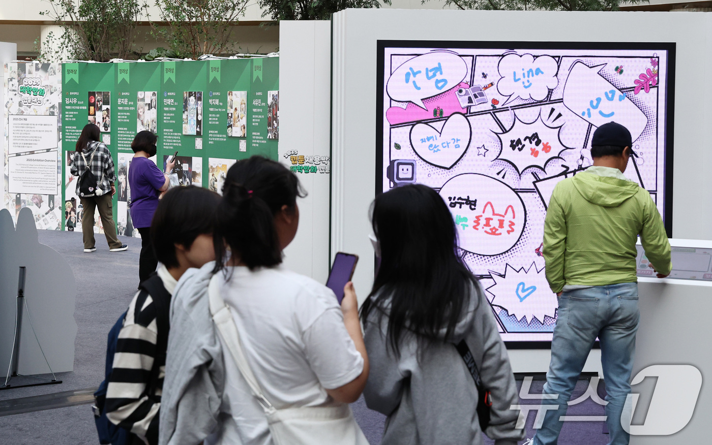 (서울=뉴스1) 구윤성 기자 = 19일 오후 서울 송파구 롯데월드 아이스링크에 마련된 '2025 월드 웹툰 페스티벌' 행사장에서 관람객들이 웹툰 전시를 둘러보고 있다.오는 22일까 …