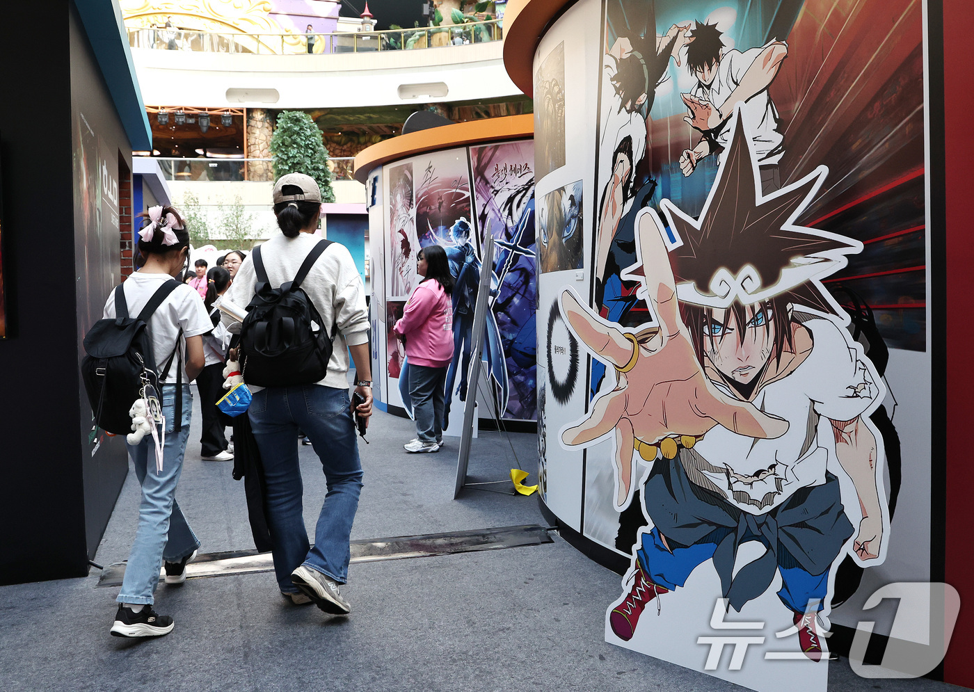 (서울=뉴스1) 구윤성 기자 = 19일 오후 서울 송파구 롯데월드 아이스링크에 마련된 '2025 월드 웹툰 페스티벌' 행사장에서 관람객들이 웹툰 전시를 둘러보고 있다.오는 22일까 …