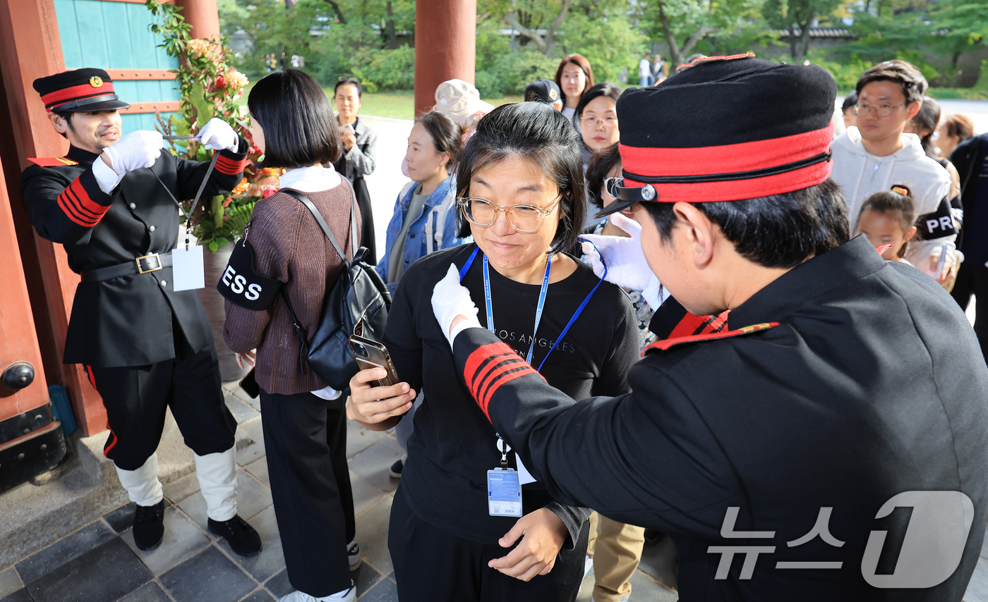 (서울=뉴스1) 이호윤 기자 = 19일 서울 중구 덕수궁 일원에서 열린 ‘2025년 대한민국 외국공사 접견례‘를 사전 예약한 시민들이 관계자들에게 기자증을 받고 있다. 이번 공연에 …