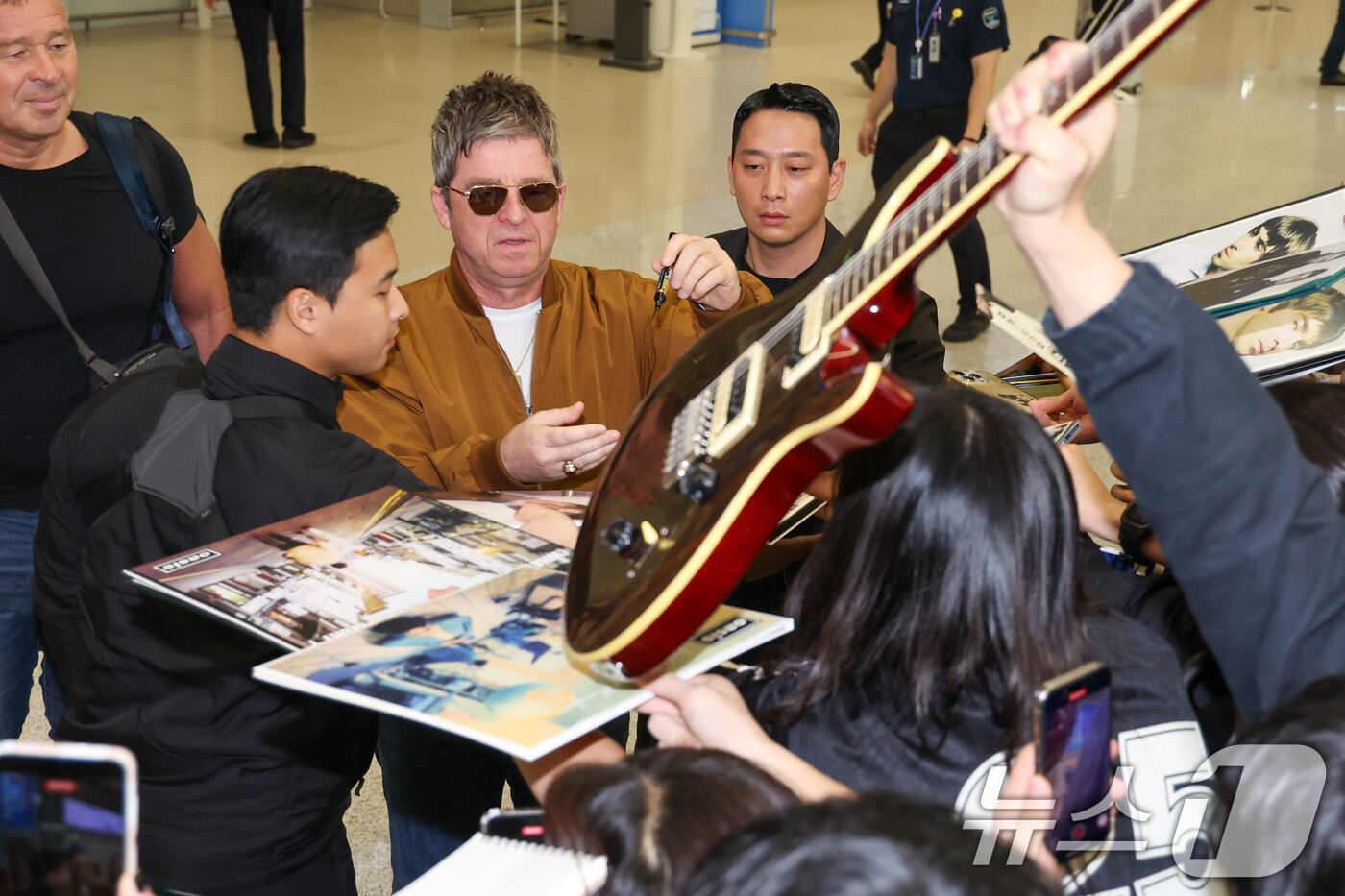 본문 이미지 - 16년 만의 내한 공연을 앞둔 밴드 오아시스(Oasis)의 노엘 갤러거(Noel Gallagher)가 19일 오후 인천국제공항 2터미널을 통해 입국하며 팬들에게 사인을 해주고 있다. 2025.10.19/뉴스1 ⓒ News1 안은나 기자