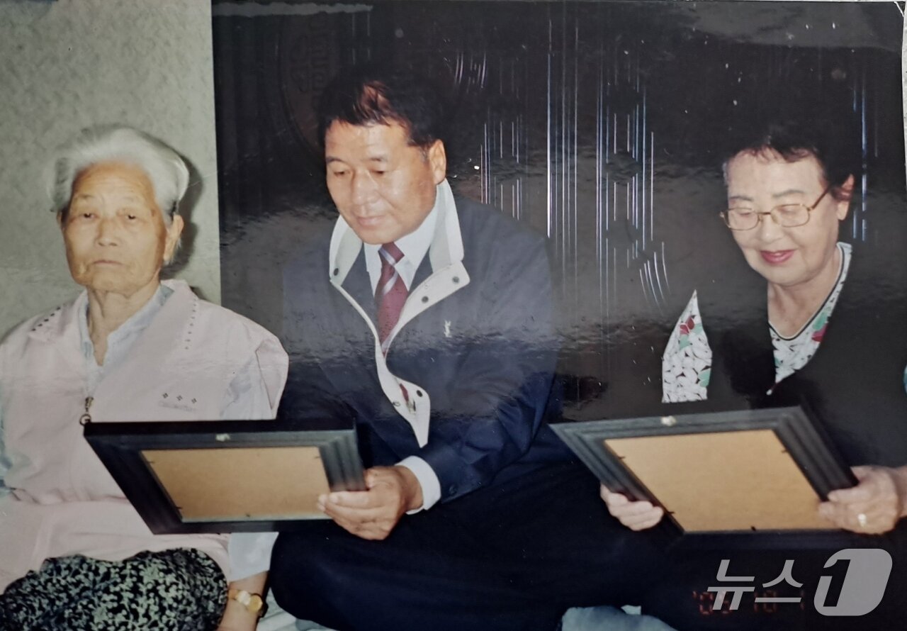 본문 이미지 - 어려운 어르신들을 위해 무료로 영정사진을 인화해 전달하는 김희만 회장의 모습