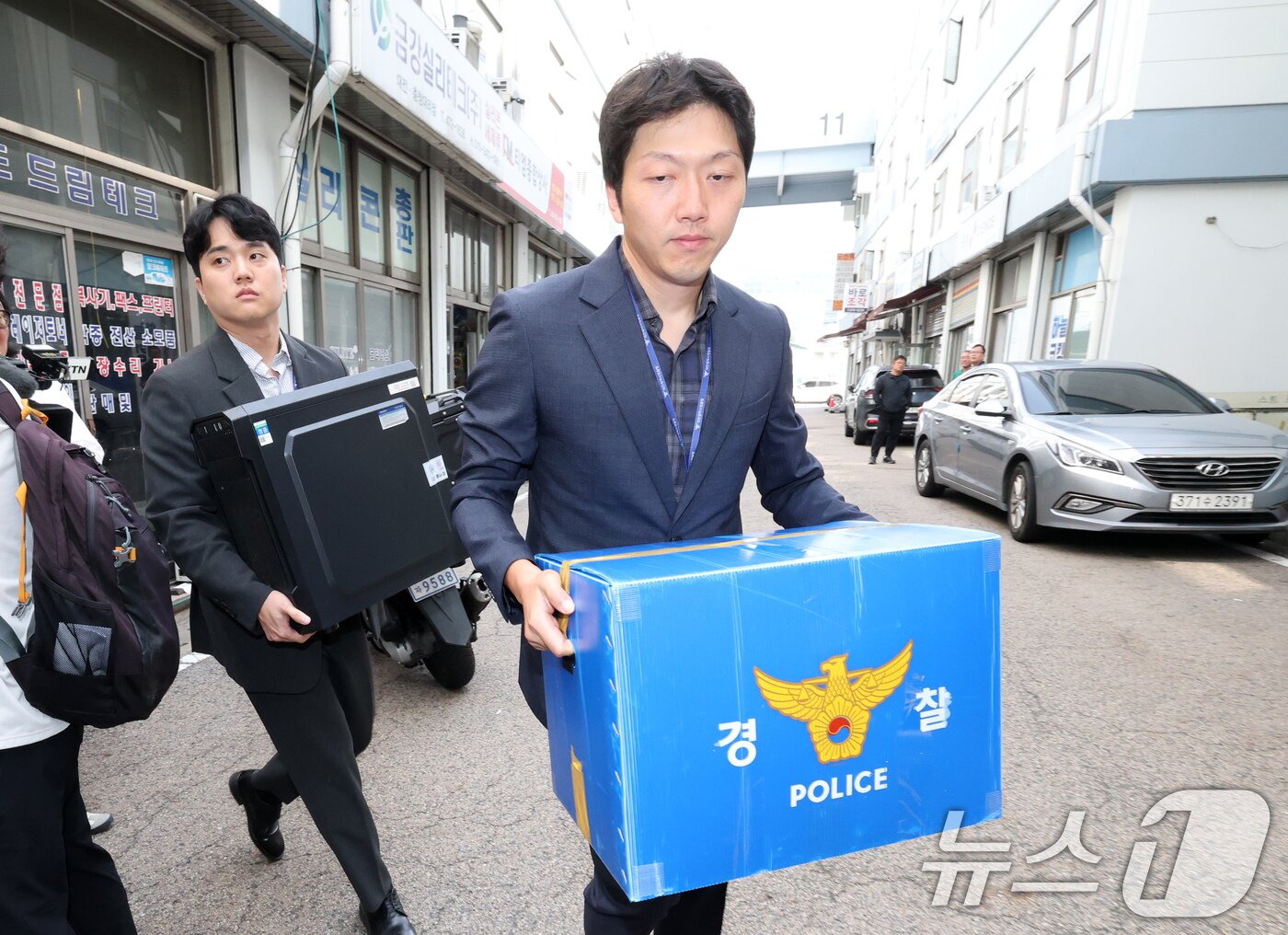 본문 이미지 - 국가정보자원관리원 화재 원인을 수사 중인 경찰이 2일 오전 9시부터 대전 국정자원과 이번 화재와 관련된 대전지역 3개 업체 등 4개소에 대한 압수수색에 들어간 가운데 무정전 전원 장치(UPS)용 리튬이온 배터리 이관 작업을 맡은 일성계전에서 압수수색을 마친 수사관들이 압수물품을 들고 이동하고 있다. 2025.10.2/뉴스1 ⓒ News1 김기태 기자