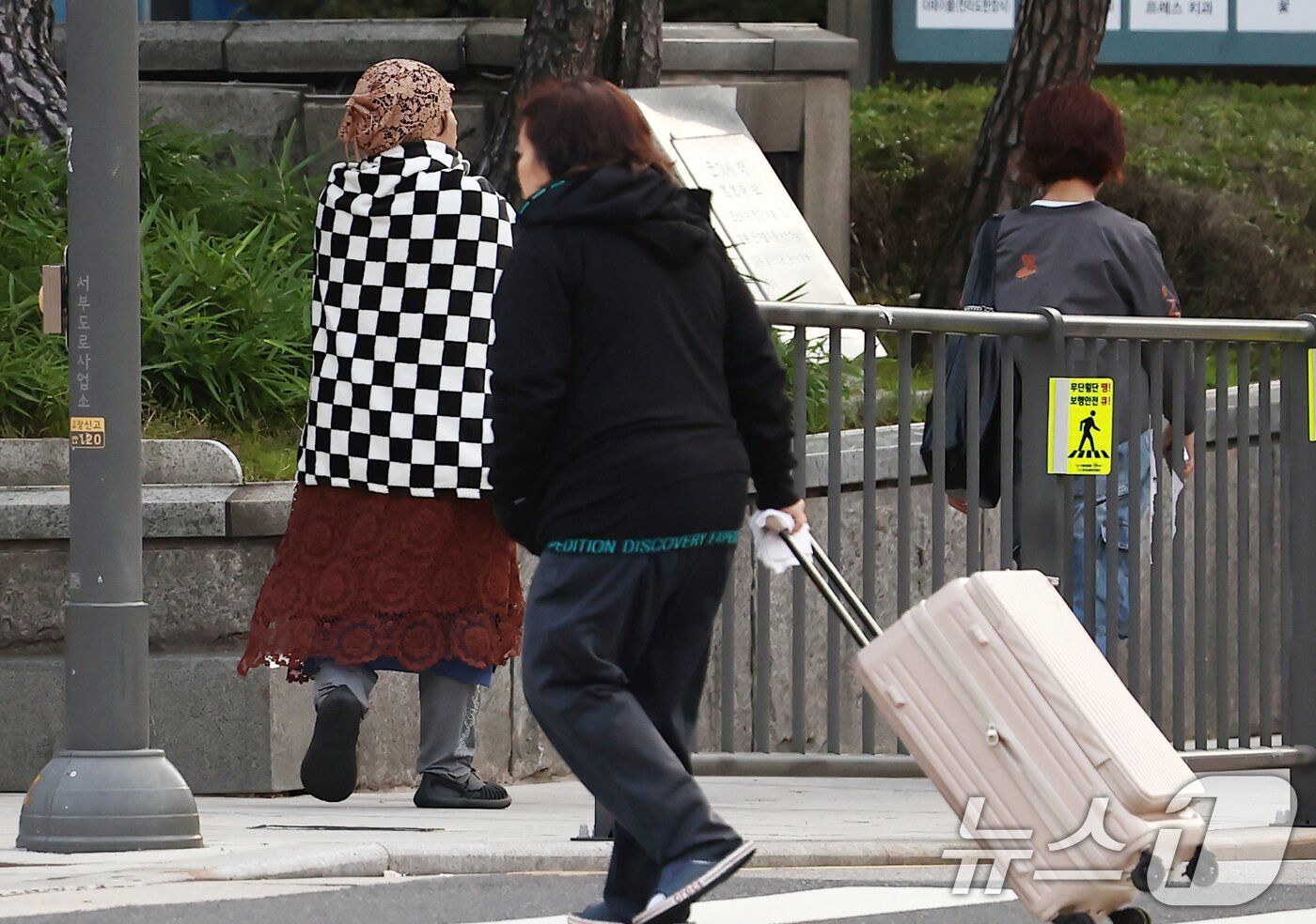 본문 이미지 - 서울을 비롯한 대부분 지역의 아침 최저 기온이 한 자릿수로 떨어지며 올가을 가장 추운 날씨를 보인 20일 오전 서울 시청역 인근에서 담요를 두른 시민이 이동하고 있다. 2025.10.20/뉴스1 ⓒ News1 김민지 기자