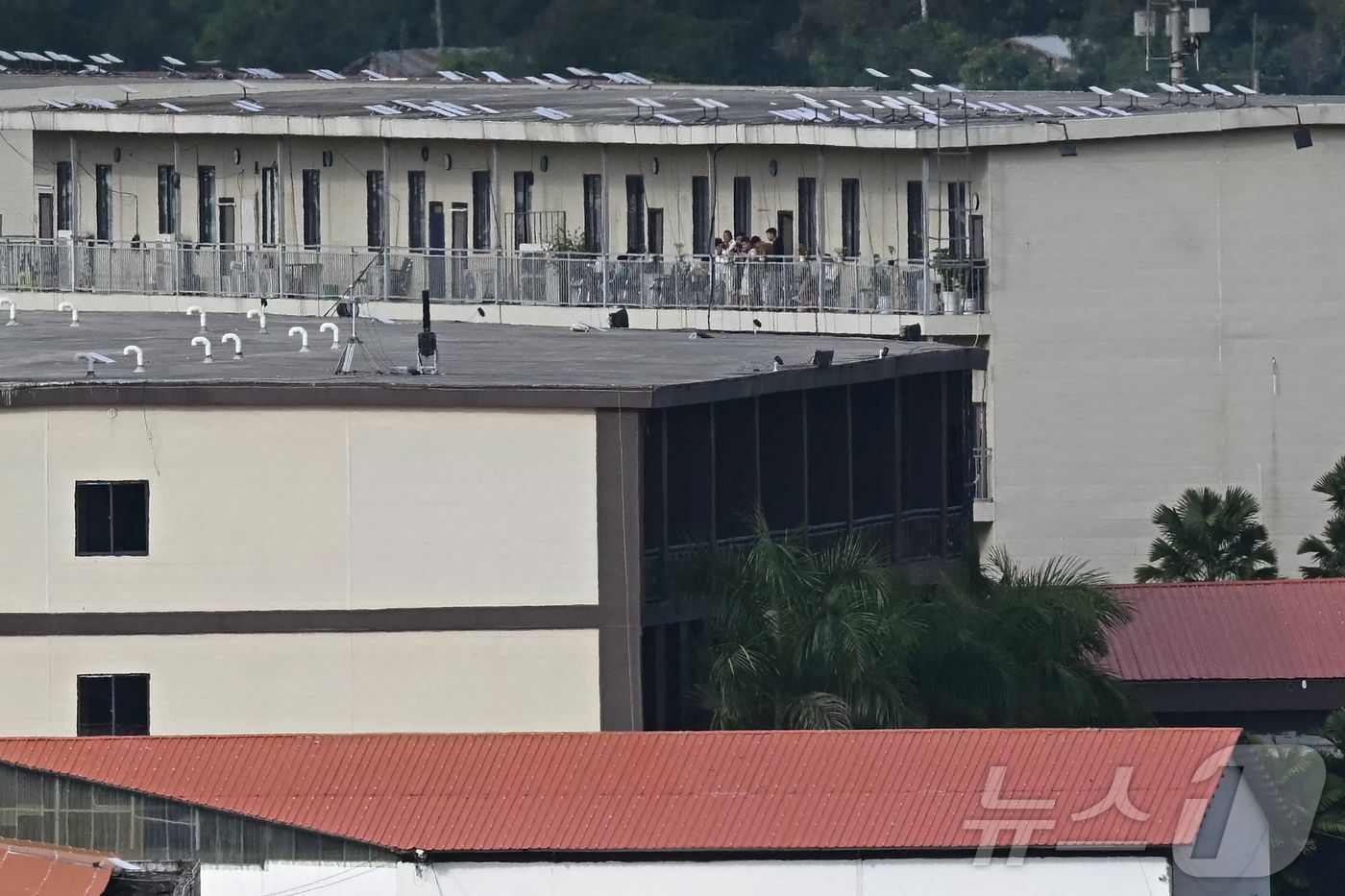 본문 이미지 - 17일(현지시간) 미얀마 동부 미야와디 타운십에 위치한 KK 파크 단지의 지붕에 스타링크 위성 접시로 추정되는 물체가 설치된 건물 발코니에 사람들이 앉아 있다. 2025.09.17. ⓒ AFP=뉴스1 ⓒNews1 이정환 기자