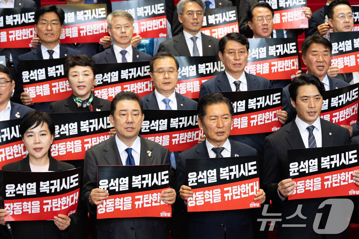 본문 이미지 - 정청래 더불어민주당 대표와 김병기 원내대표를 비롯한 의원들이 지난 20일 서울 여의도 국회 로텐더홀에서 열린 내란수괴 면회 극우선동 장동혁 규탄 기자회견에서 손팻말을 들고 구호를 외치고 있다. 2025.10.20/뉴스1 ⓒ News1 유승관 기자