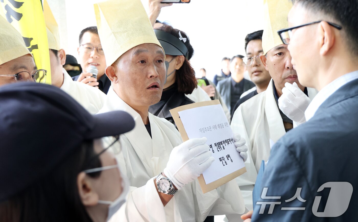 본문 이미지 - 자임유가족협의회 관계자들이 20일 전북 전주시 전북특별자치도청 앞에서 자임추모관 사태 해결 촉구 행진에 앞서 전북도 관계자에게 김관영 전북특별자치도지사 면담 요청 성명서를 전달하고 있다. ⓒ News1 유경석 기자