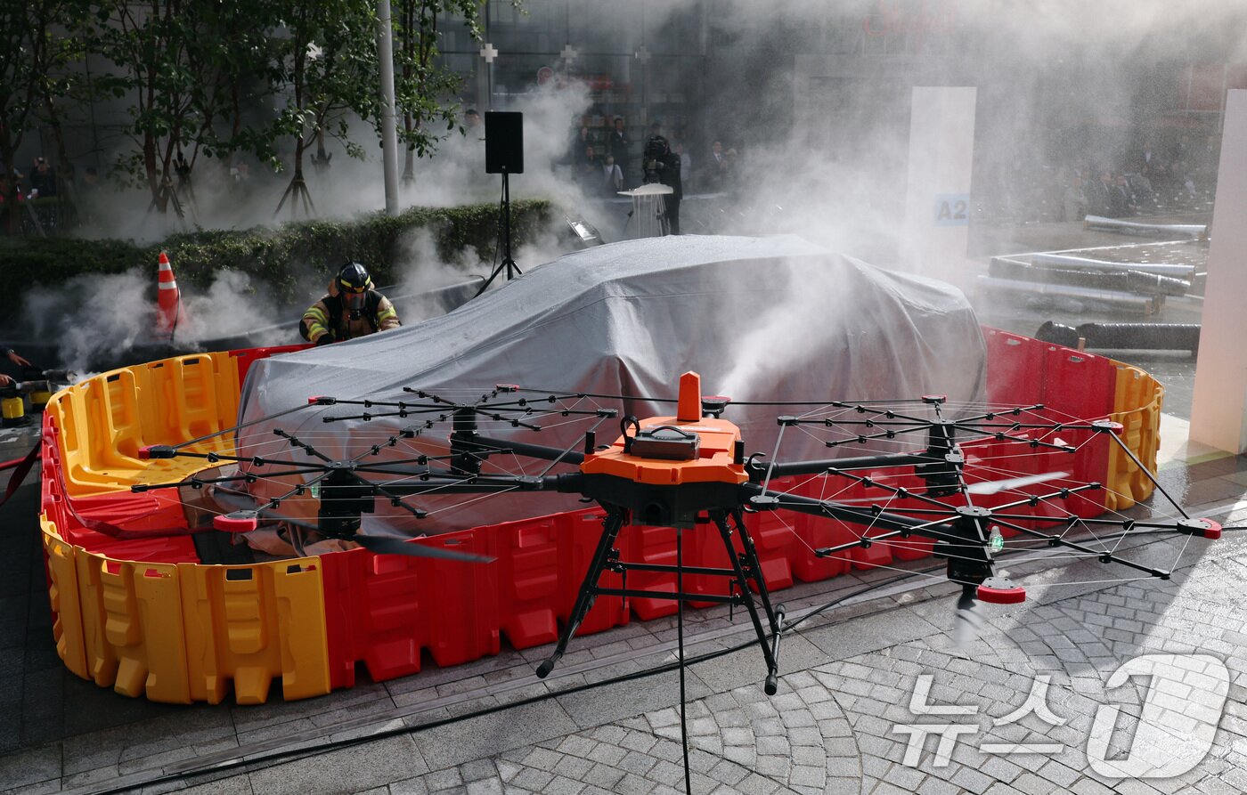 본문 이미지 - 20일 오후 서울 강남구 코엑스에서 열린 '2025 강남구 안전한국훈련'에서 소방대원과 소방드론이 이동식 소화수조에 물을 채워 전기차 화재를 진압하고 있다. 2025.10.20/뉴스1 ⓒ News1 구윤성 기자