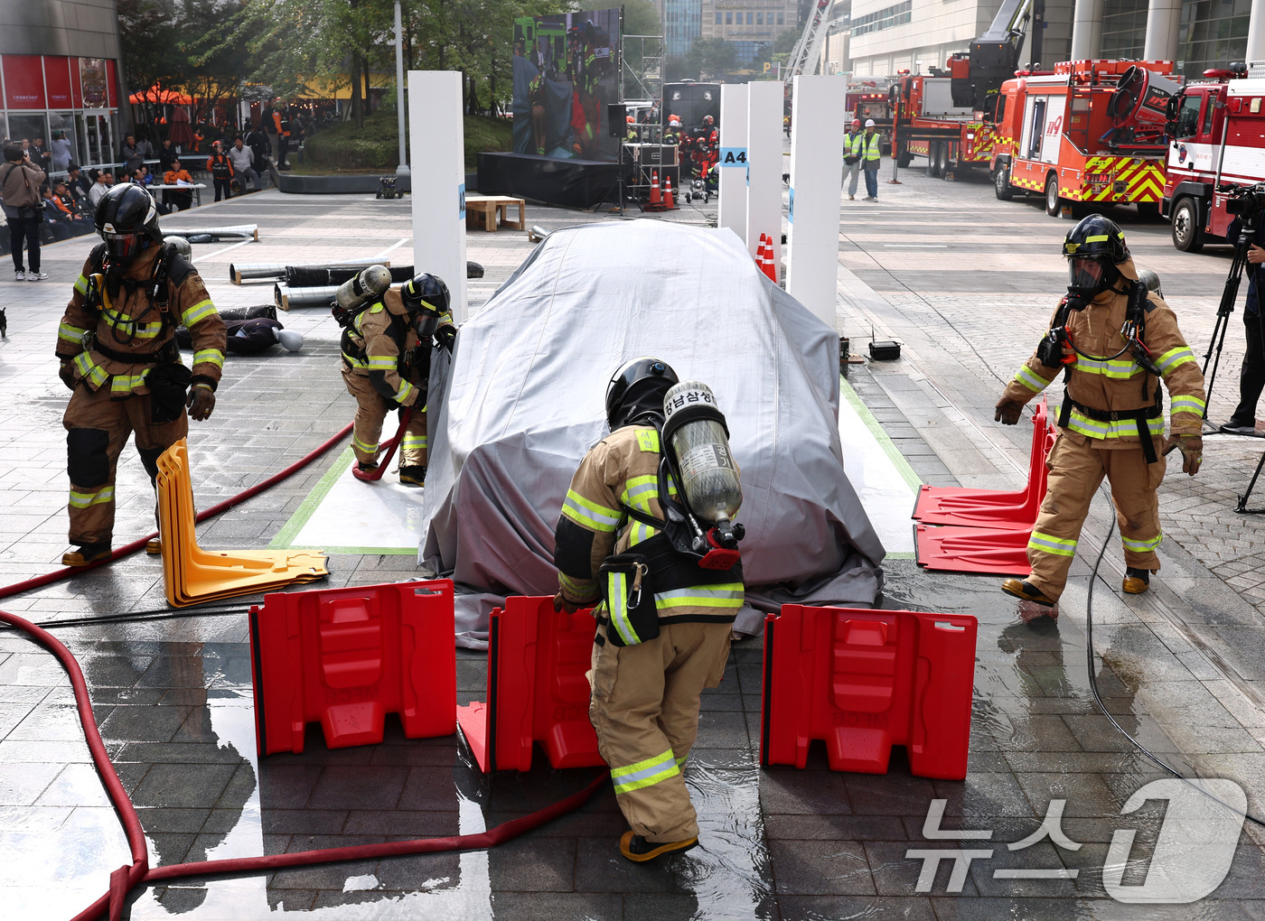 (서울=뉴스1) 구윤성 기자 = 20일 오후 서울 강남구 코엑스에서 열린 '2025 강남구 안전한국훈련'에서 소방대원들이 전기차 화재진압을 위해 이동식 소화수조를 조립하고 있다. …