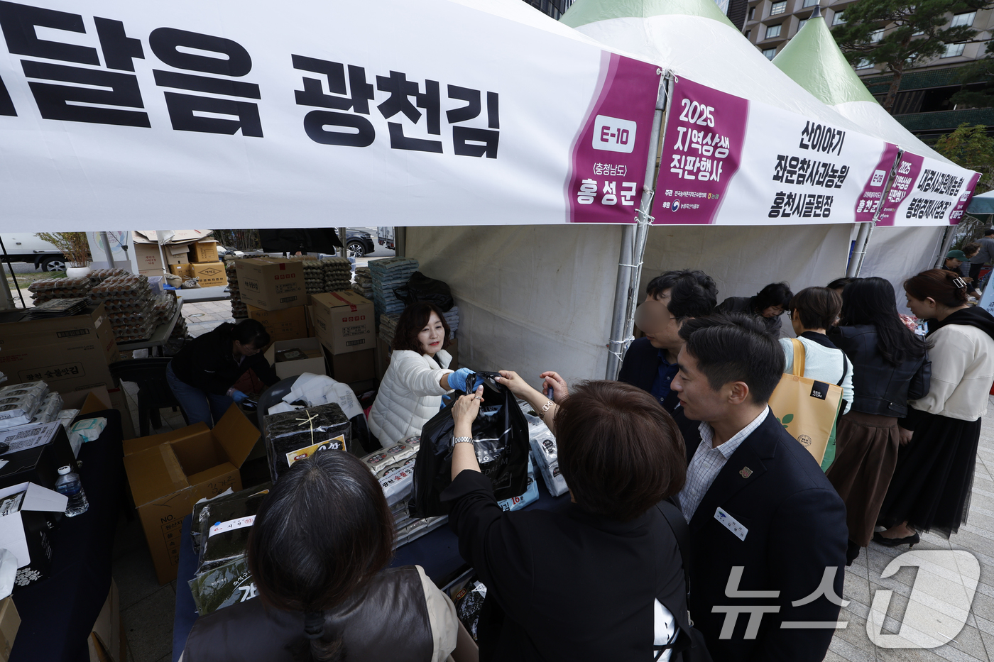 (서울=뉴스1) 박정호 기자 = 20일 오후 서울 중구 서울광장에서 전국농어촌지역군수협의회와 NH농협중앙회가 함께한 2025 지역상생 직판행사를 찾은 시민들이 각 지역 부스에서 물 …