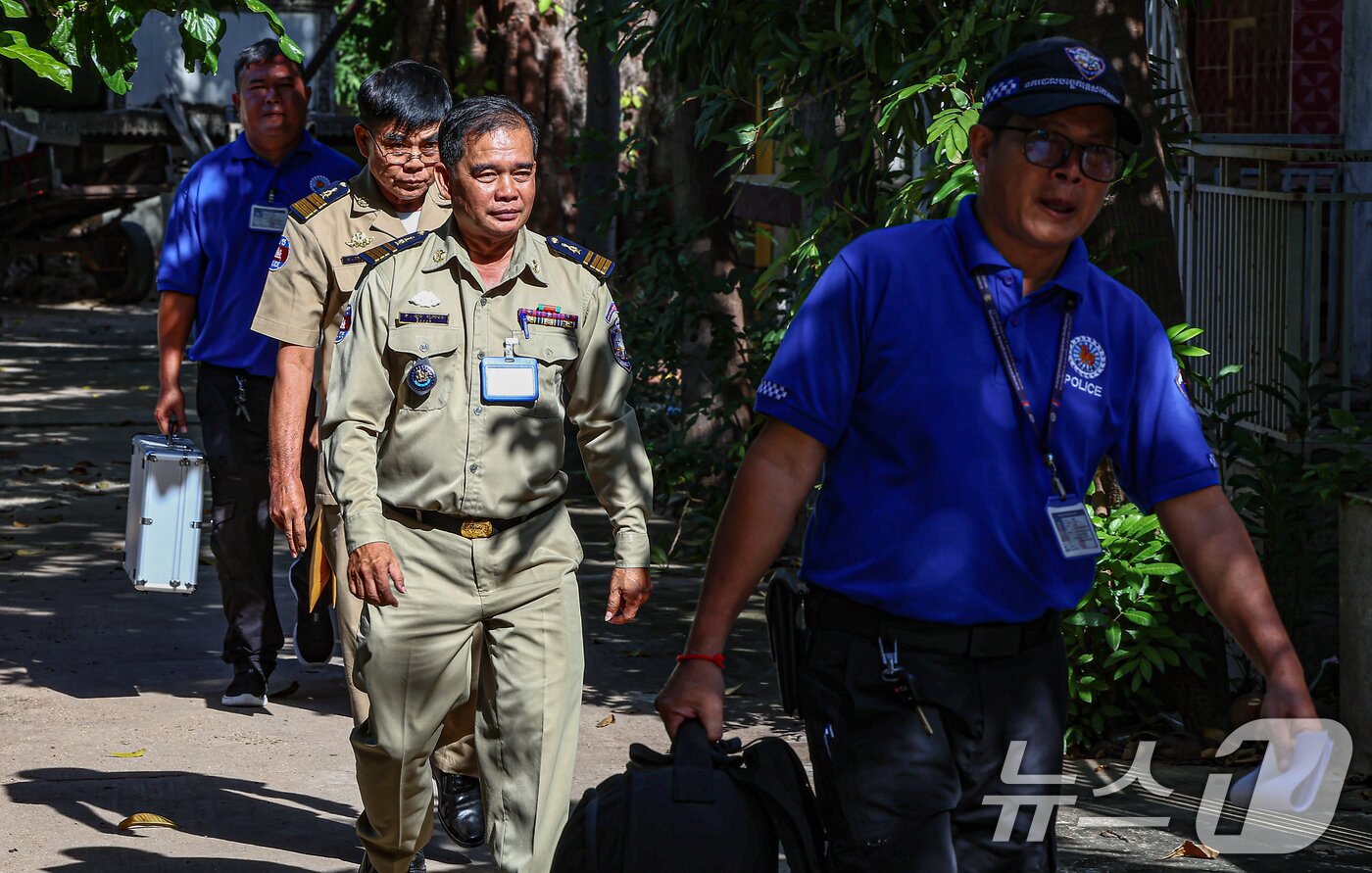 본문 이미지 - 캄보디아 측 경찰 관계자들이 20일(현지시간) 캄보디아 프놈펜 턱틀라사원에서 지난 8월 보코산 지역의 온라인스캠범죄단지에 감금돼 고문 끝에 숨진 대학생 박모씨의 시신 부검 및 화장을 마치고 사원을 나서고 있다. 2025.10.20/뉴스1 ⓒ News1 김도우 기자