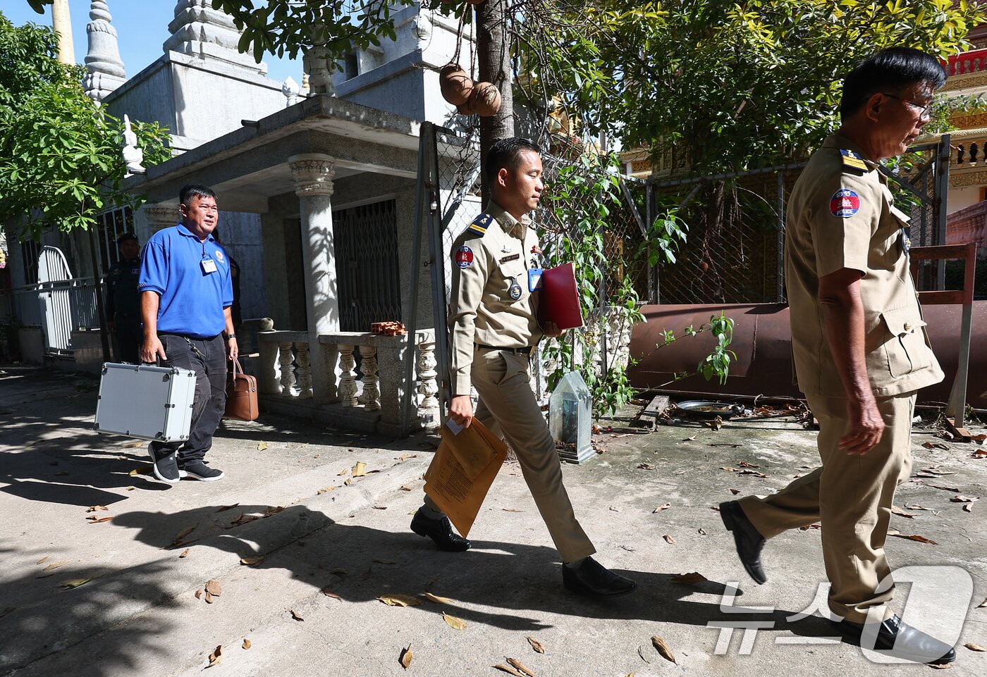 본문 이미지 - 캄보디아 측 경찰 관계자들이 20일&#40;현지시간&#41; 캄보디아 프놈펜 턱틀라사원에서 지난 8월 보코산 지역의 온라인스캠범죄단지에 감금돼 고문 끝에 숨진 대학생 박모씨의 시신 부검 및 화장을 마치고 사원을 나서고 있다. 2025.10.20/뉴스1 ⓒ News1 김도우 기자