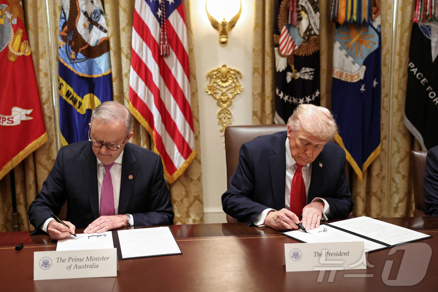 본문 이미지 - 20일&#40;현지시간&#41; 도널드 트럼프 미국 대통령&#40;오른쪽&#41;과 앤서니 앨버니지 호주 총리가 워싱턴 백악관에서 핵심 광물·희토류 협정에 서명하고 있다. 2025.10.20 ⓒ 로이터=뉴스1 ⓒ News1 김지완 기자
