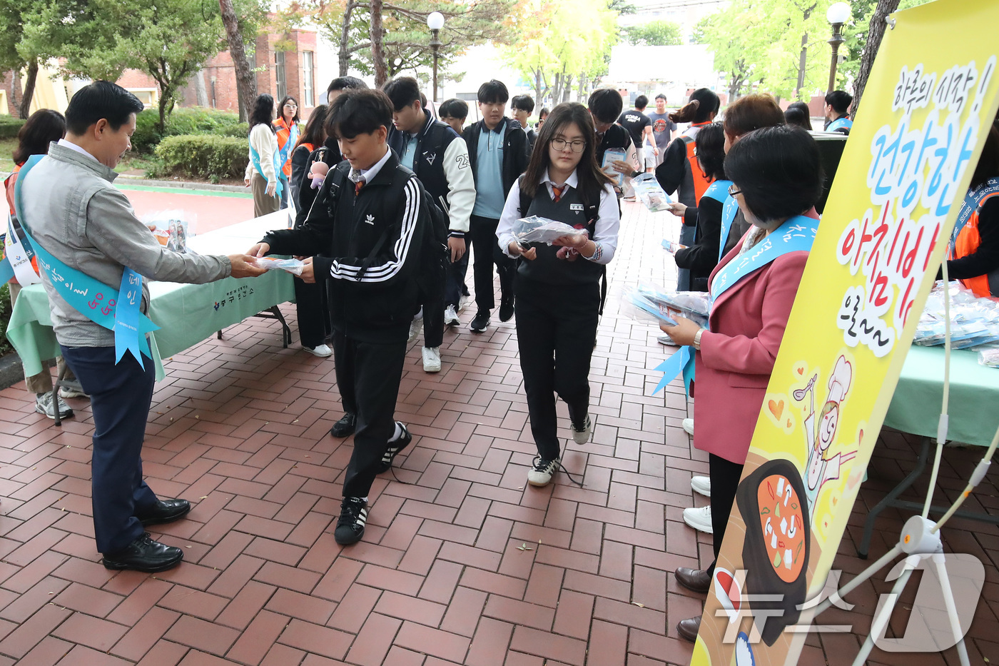 (대구=뉴스1) 공정식 기자 = 21일 오전 대구 중구 계성중학교에서 중구보건소와 중구청 관계자들이 등굣길 학생들에게 떡과 아침밥 건강정보 안내문을 나눠주며 '아침 결식 예방 캠페 …