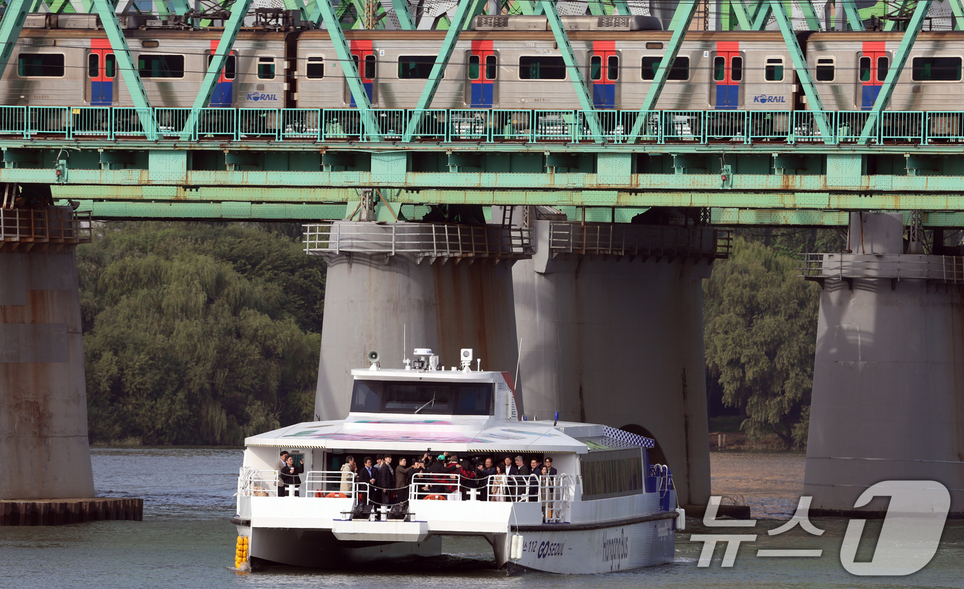 (서울=뉴스1) 김명섭 기자 = 21일 서울 용산구 노들섬에서 열린 '노들 글로벌 예술섬' 착공식에 참석자를 태운 한강버스가 한강철교 아래를 지나고 있다. 2025.10.21/뉴스 …