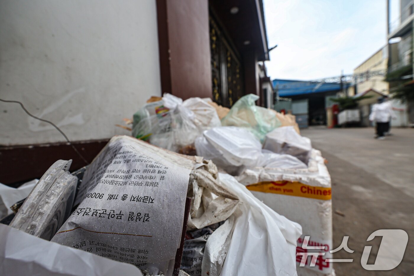 본문 이미지 - 21일&#40;현지시간&#41; 캄보디아 프놈펜 외곽 온라인스캠범죄가 이뤄졌던 건물 앞에 한국 신문이 버려져 있다. 현지 언론에 따르면 이곳에서 지난달 15일 캄보디아 당국의 단속으로 온라인스캠범죄에 가담한 한국인 33명을 포함해 48명을 체포했다. 2025.10.21/뉴스1 ⓒ News1 김도우 기자
