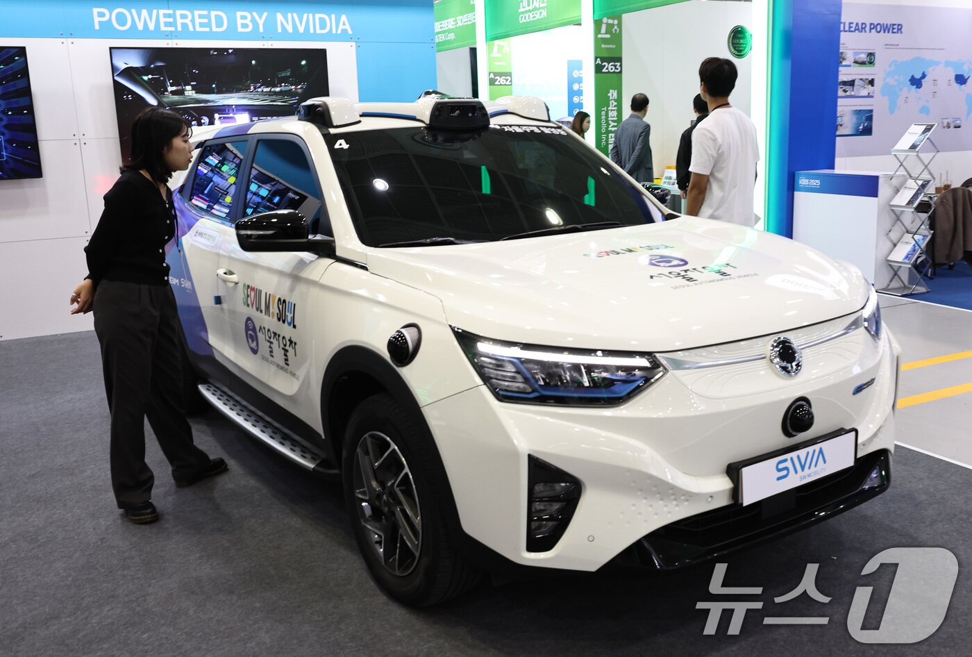 본문 이미지 - 21일 서울 강남구 코엑스에서 열린 &#39;2025 한국전자전&#40;KES&#41;&#39;에서 참관객이 현재 강남구에서 운행중인 서울자율택시를 살펴보고 있다. 2025.10.21/뉴스1 ⓒ News1 구윤성 기자