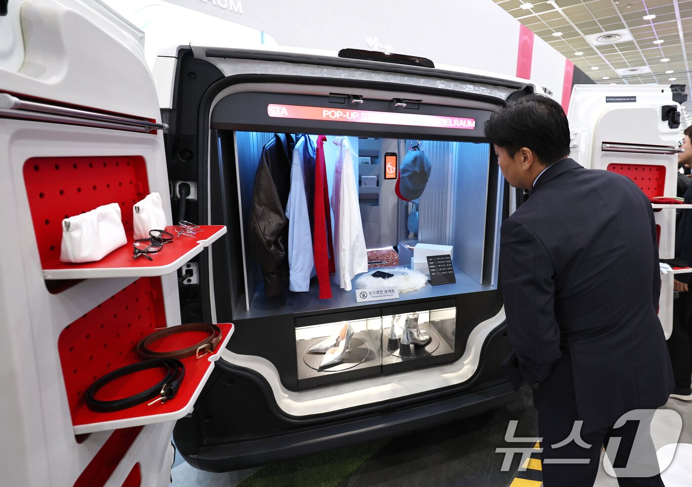 본문 이미지 - 21일 서울 강남구 코엑스에서 열린 &#39;2025 한국전자전&#40;KES&#41;&#39;에서 참관객이 전기차에 마련된 팝업스토어를 살펴보고 있다. 2025.10.21/뉴스1 ⓒ News1 구윤성 기자