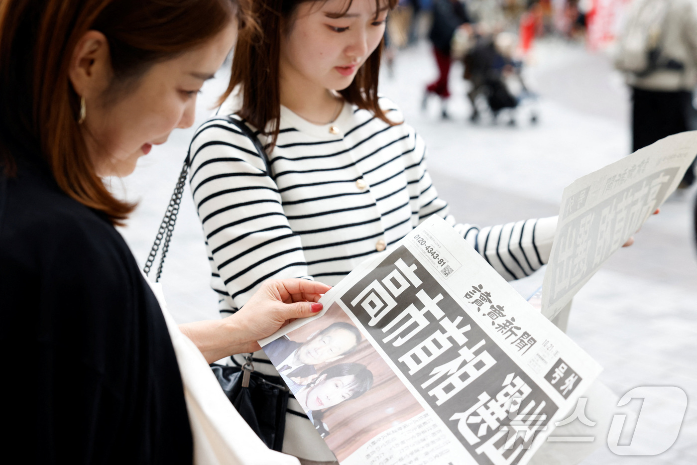 (도쿄 로이터=뉴스1) 최종일 선임기자 = 일본 도쿄 거리에서 21일 다카이치 사나에 자민당 총재가 일본의 첫 여성 총리로 선출됐다는 요미우리 신문의 호외 기사를 여성들이 읽고 있 …