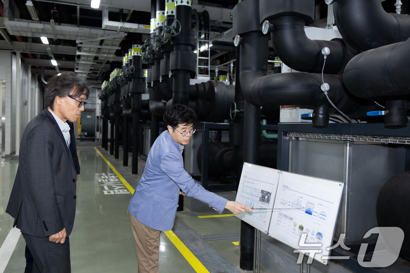 (서울=뉴스1) = 금한승 기후에너지환경부 1차관이 21일 서울 송파구 롯데월드타워를 방문해 롯데월드타워의 수열 에너지 시설을 살펴보며 활용 현황과 효과 설명을 듣고 있다. (기후 …