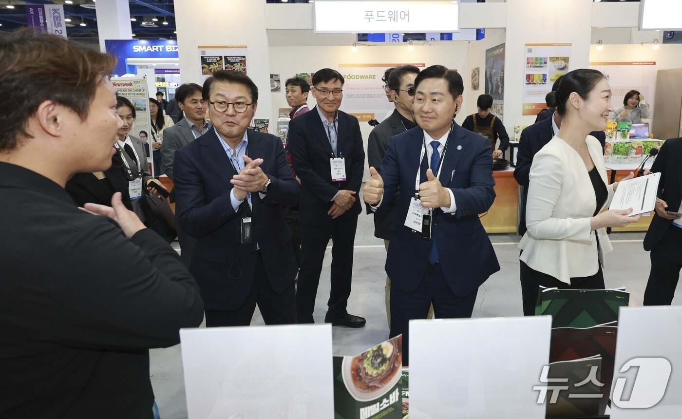 본문 이미지 -  21일 서울 코엑스에서 '2025 스마트비즈엑스포' 행사 일환으로 삼성전자 스마트공장 지원사업 10주년 기념식이 개최된 가운데 김관영 전북도지사와 박승희 삼성전자 사장 등이 전북 참여기업 부스를 방문, 격려하고 있다.(전북도 제공. 재판매 및 DB금지)/뉴스1 