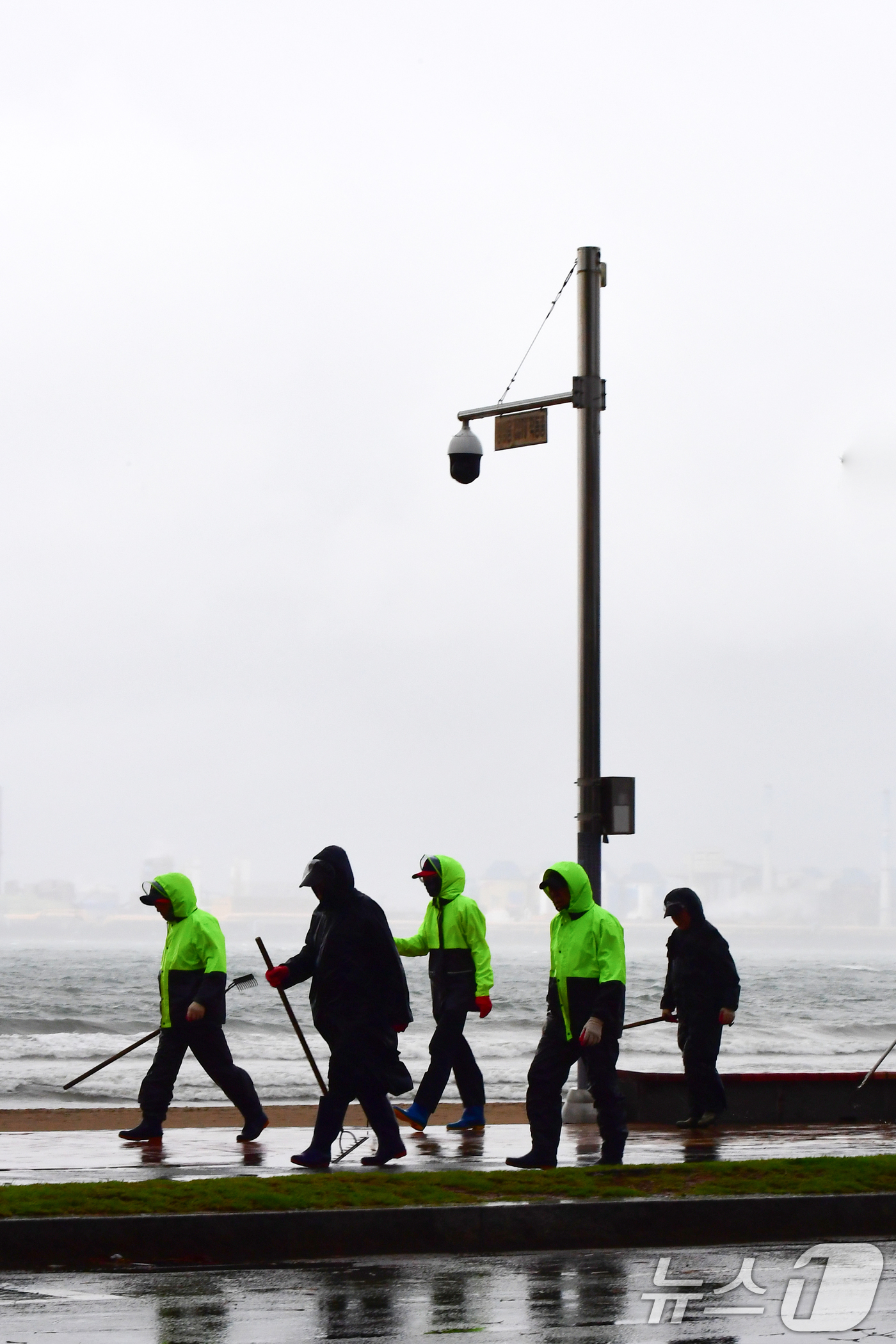 (포항=뉴스1) 최창호 기자 = 22일 오전 경북 포항시 전역에 비가 내리는 가운데 영일대해수욕장 해안도로에서 우비를 입은 공공 근로자들이 걸어가고 있다. 2025.10.22/뉴스 …