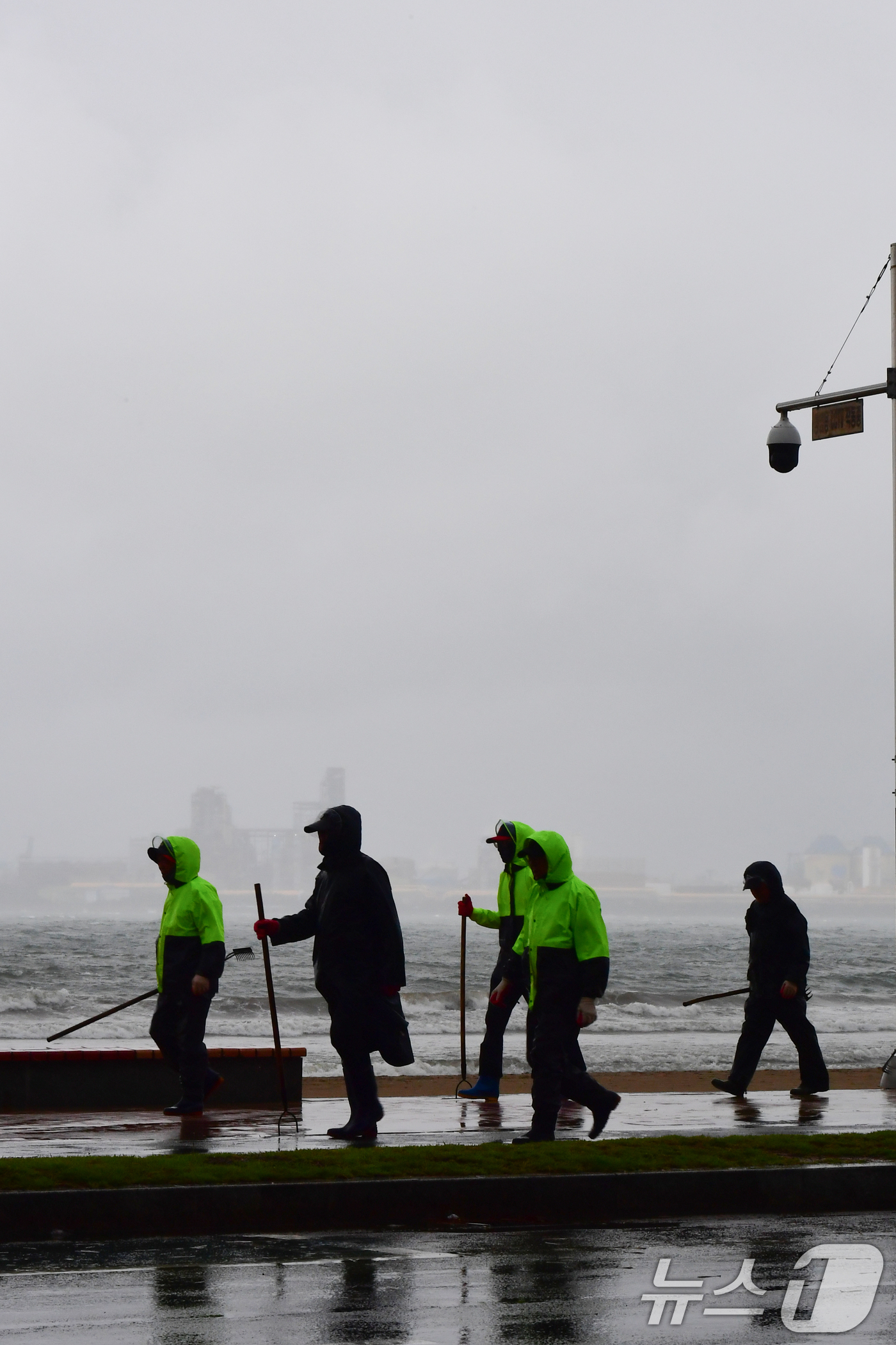(포항=뉴스1) 최창호 기자 = 22일 오전 경북 포항시 전역에 비가 내리는 가운데 영일대해수욕장 해안도로에서 우비를 입은 공공 근로자들이 걸어가고 있다. 2025.10.22/뉴스 …