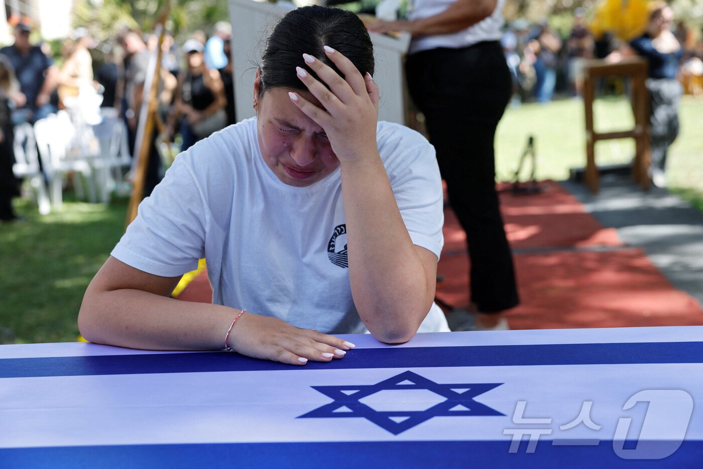 본문 이미지 - 21일(현지시간) 사망 인질 로넨 엥겔의 딸 유발이 이스라엘군에 따르면 2023년 10월 7일 하마스의 치명적인 공격 당시 가족을 지키다 사망한 아버지의 장례 행렬에서 아버지를 애도하고 있다. 2025.10.21. ⓒ 로이터=뉴스1 ⓒ News1 이정환 기자