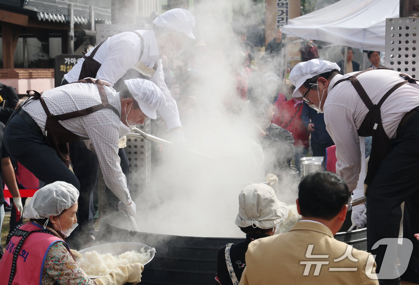 본문 이미지 - ‘제24회 이천쌀문화축제’가 개막한 22일 경기 이천시 모가면 이천농업테마공원에서 행사 관계자들이 2000인분 가마솥 밥을 푸고 있다. 2025.10.22/뉴스1 ⓒ News1 김영운 기자