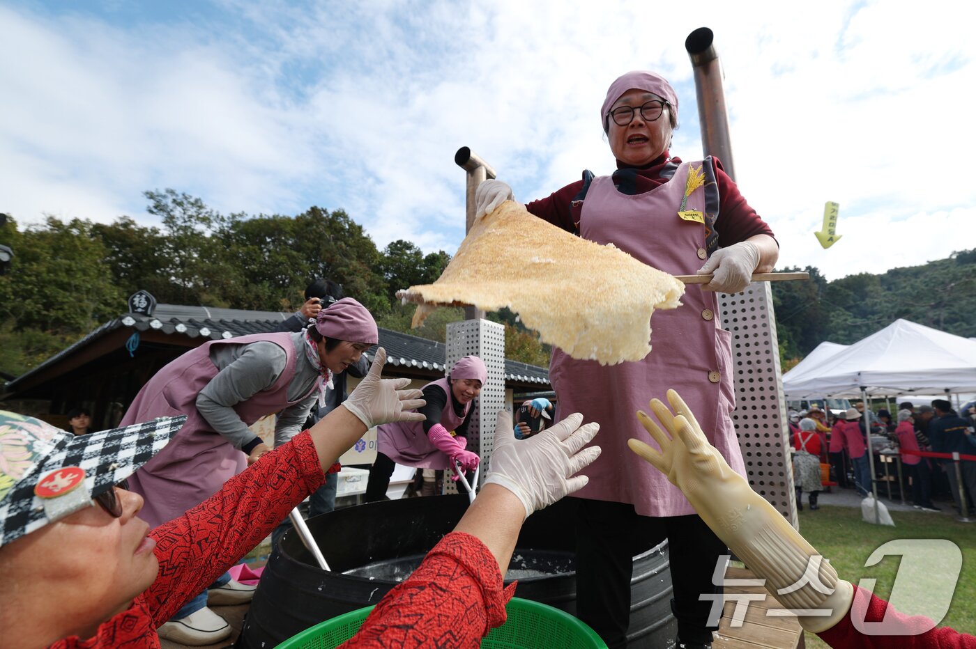 본문 이미지 - ‘제24회 이천쌀문화축제’가 개막한 22일 경기 이천시 모가면 이천농업테마공원에서 행사 관계자들이 2000인분 가마솥에서 누룽지를 긁고 있다. 2025.10.22/뉴스1 ⓒ News1 김영운 기자