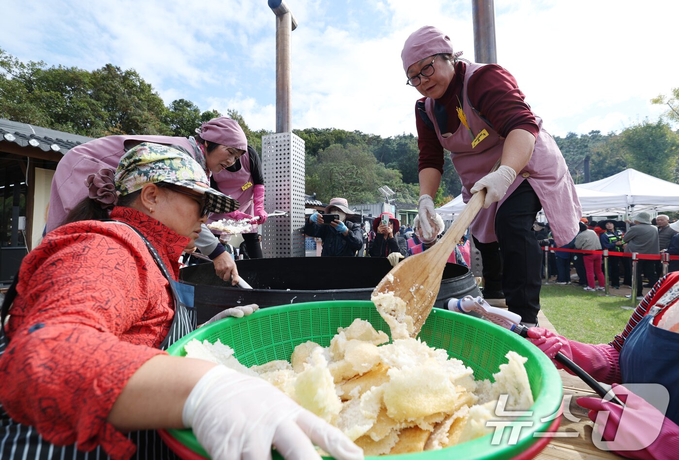 본문 이미지 - ‘제24회 이천쌀문화축제’가 개막한 22일 경기 이천시 모가면 이천농업테마공원에서 행사 관계자들이 2000인분 가마솥에서 누룽지를 긁고 있다. 2025.10.22/뉴스1 ⓒ News1 김영운 기자