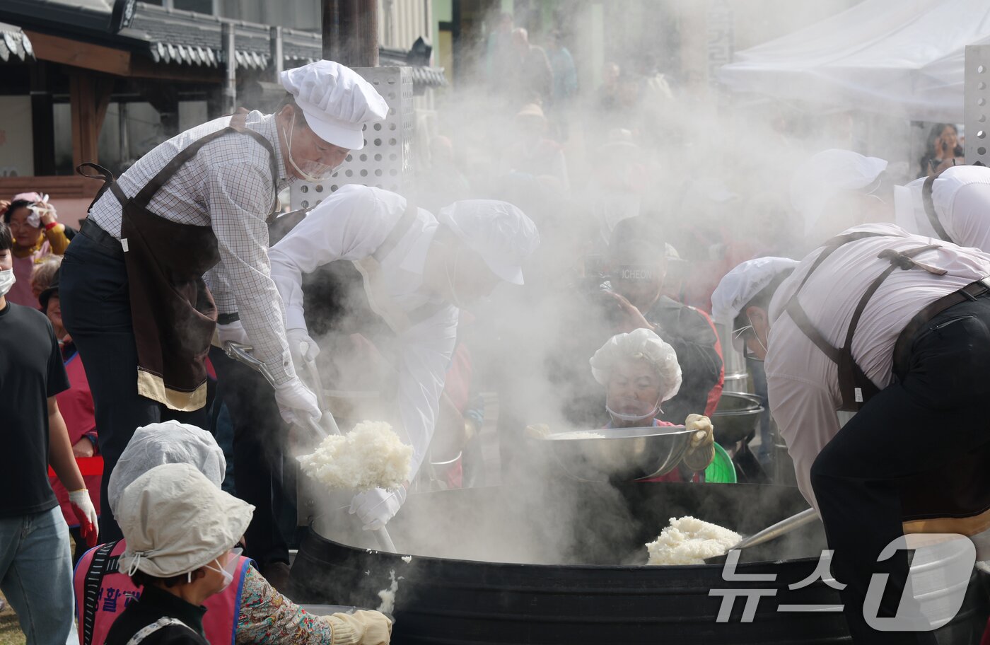 본문 이미지 - ‘제24회 이천쌀문화축제’가 개막한 22일 경기 이천시 모가면 이천농업테마공원에서 행사 관계자들이 2000인분 가마솥 밥을 푸고 있다. 2025.10.22/뉴스1 ⓒ News1 김영운 기자
