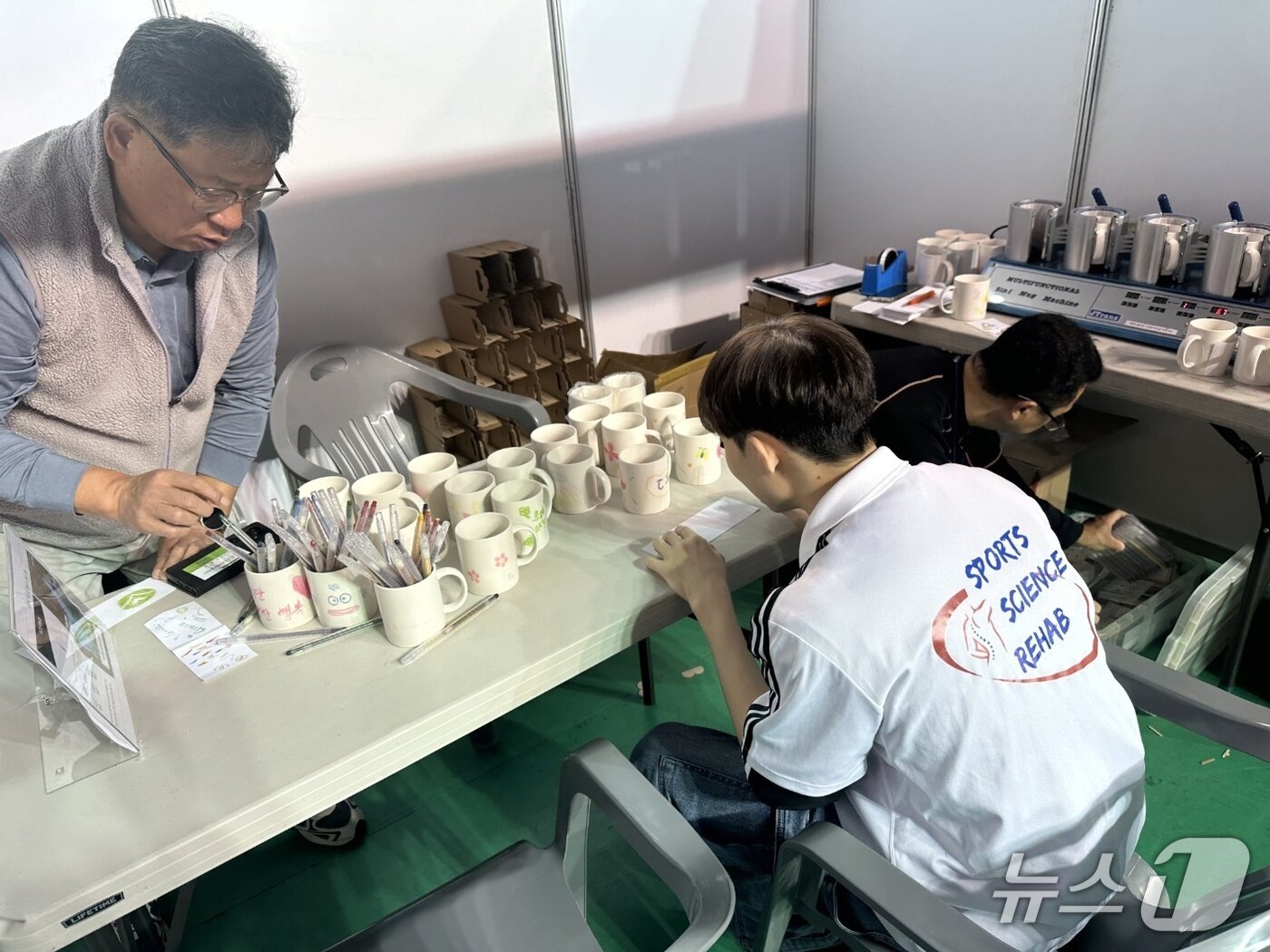 본문 이미지 -  &#39;제2회 사회서비스 일자리+산업박람회&#39; 행사장 내에 마련된 전북신산업융합지원단의 부스에서 한 관람객이 &#39;전사 머그컵 만들기&#39; 체험을 하고 있다.&#40;전북사회서비스원 제공. 재판매 및 DB금지&#41;/뉴스1