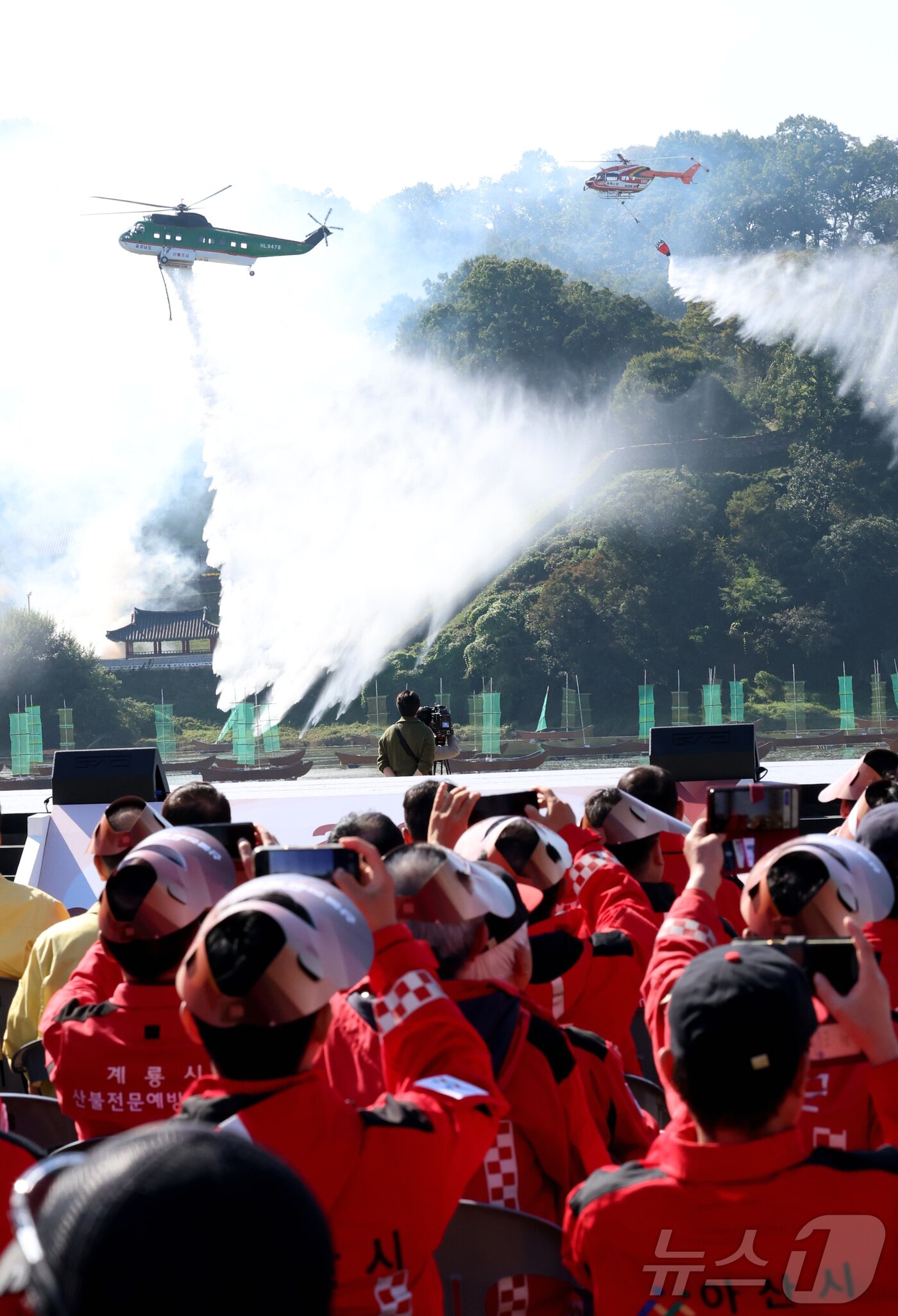 본문 이미지 - 22일 오전 충남 공주시 금강변에서 열린 2025 산불진화 통합훈련에서 산불진화 헬기들이 공중 진화를 전개하고 있다. 이날 훈련은 충남, 공주, 산림청, 소방, 군, 경찰, 기상청 등 7개 기관 총 650여 명이 참여했다. 2025.10.22/뉴스1 ⓒ News1 김기남 기자