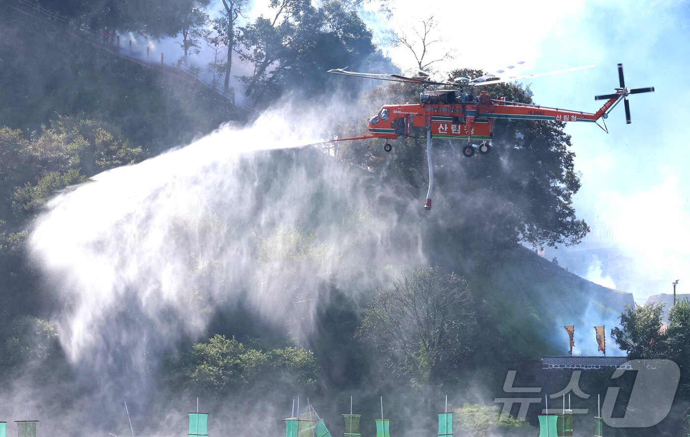 본문 이미지 - 22일 오전 충남 공주시 금강변에서 열린 2025 산불진화 통합훈련에서 산불진화 헬기들이 공중 진화를 전개하고 있다. 이날 훈련은 충남, 공주, 산림청, 소방, 군, 경찰, 기상청 등 7개 기관 총 650여 명이 참여했다. 2025.10.22/뉴스1 ⓒ News1 김기남 기자