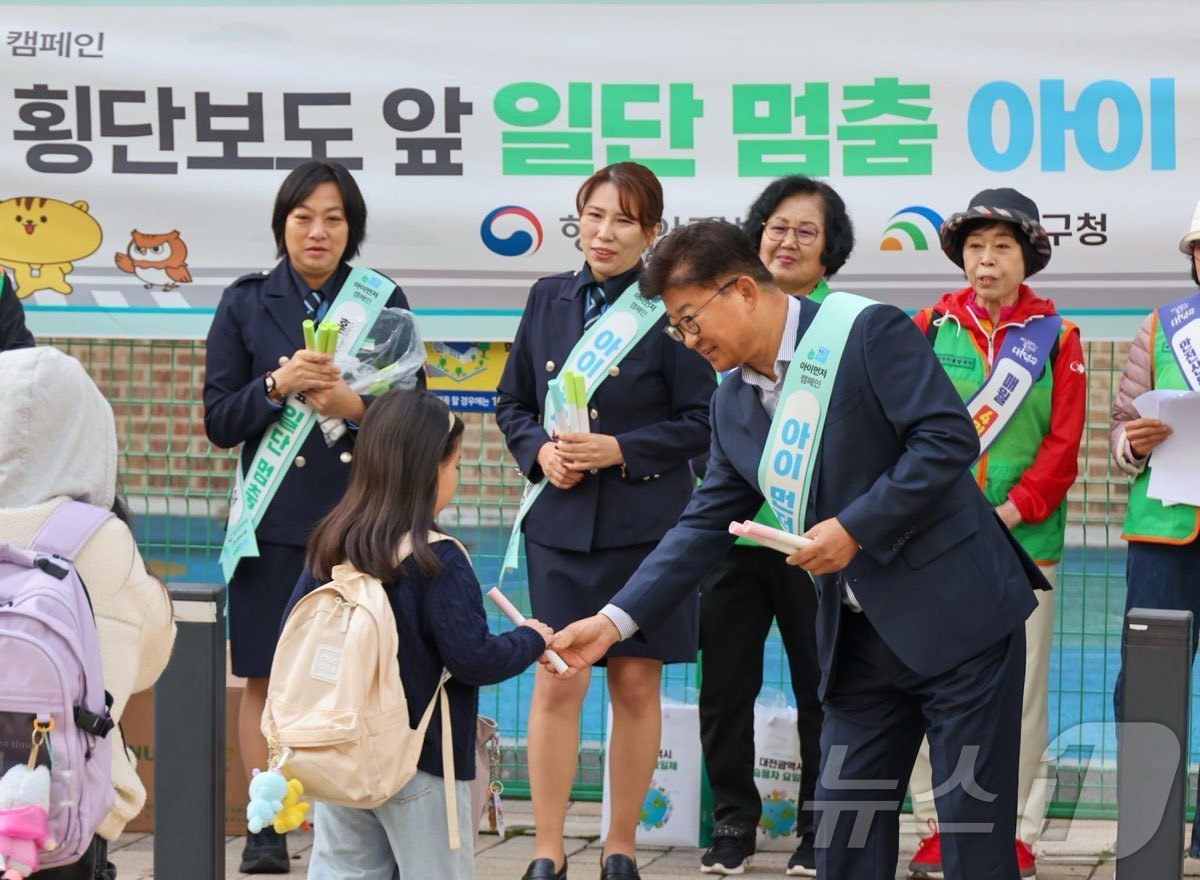 (대전=뉴스1) 김기태 기자 = 최충규 대전 대덕구청장이 22일 석봉동 새여울초등학교 정문 앞에서 어린이 교통사고 예방 및 안전한 통학 환경 조성 캠페인에 참여해 등교하는 학생들에 …