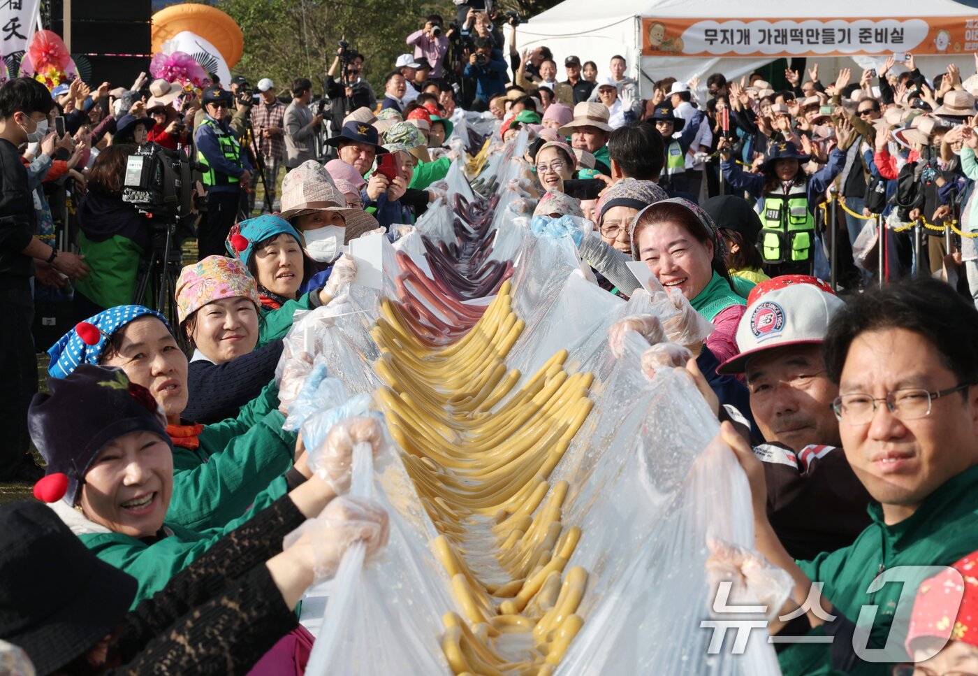 본문 이미지 - ‘제24회 이천쌀문화축제’가 개막한 22일 경기 이천시 모가면 이천농업테마공원에서 행사 관계자들이 600m 가래떡을 만들고 기념촬영을 하고 있다. 2025.10.22/뉴스1 ⓒ News1 김영운 기자