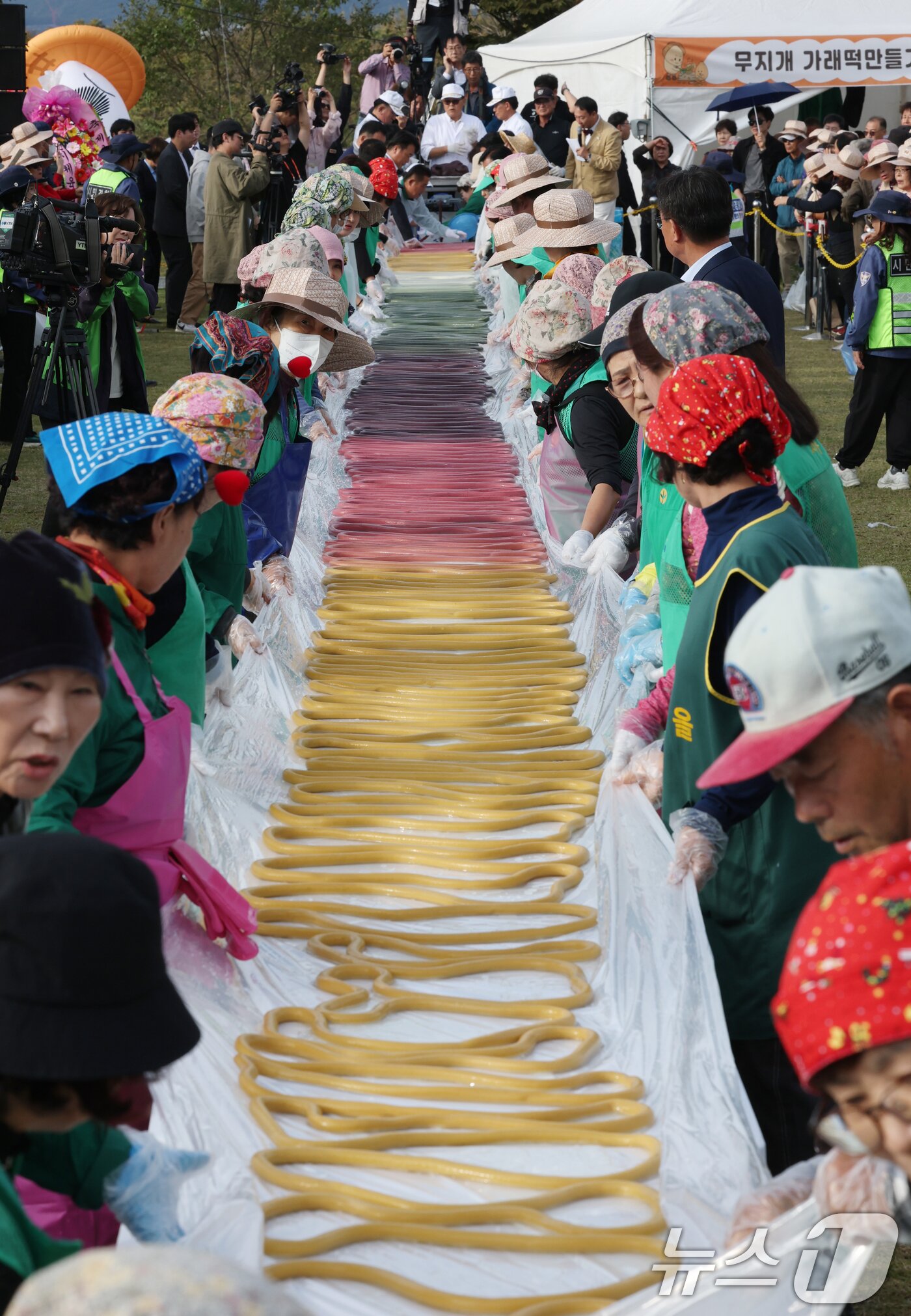 본문 이미지 - ‘제24회 이천쌀문화축제’가 개막한 22일 경기 이천시 모가면 이천농업테마공원에서 행사 관계자들이 600m 가래떡을 만들고 있다. 2025.10.22/뉴스1 ⓒ News1 김영운 기자