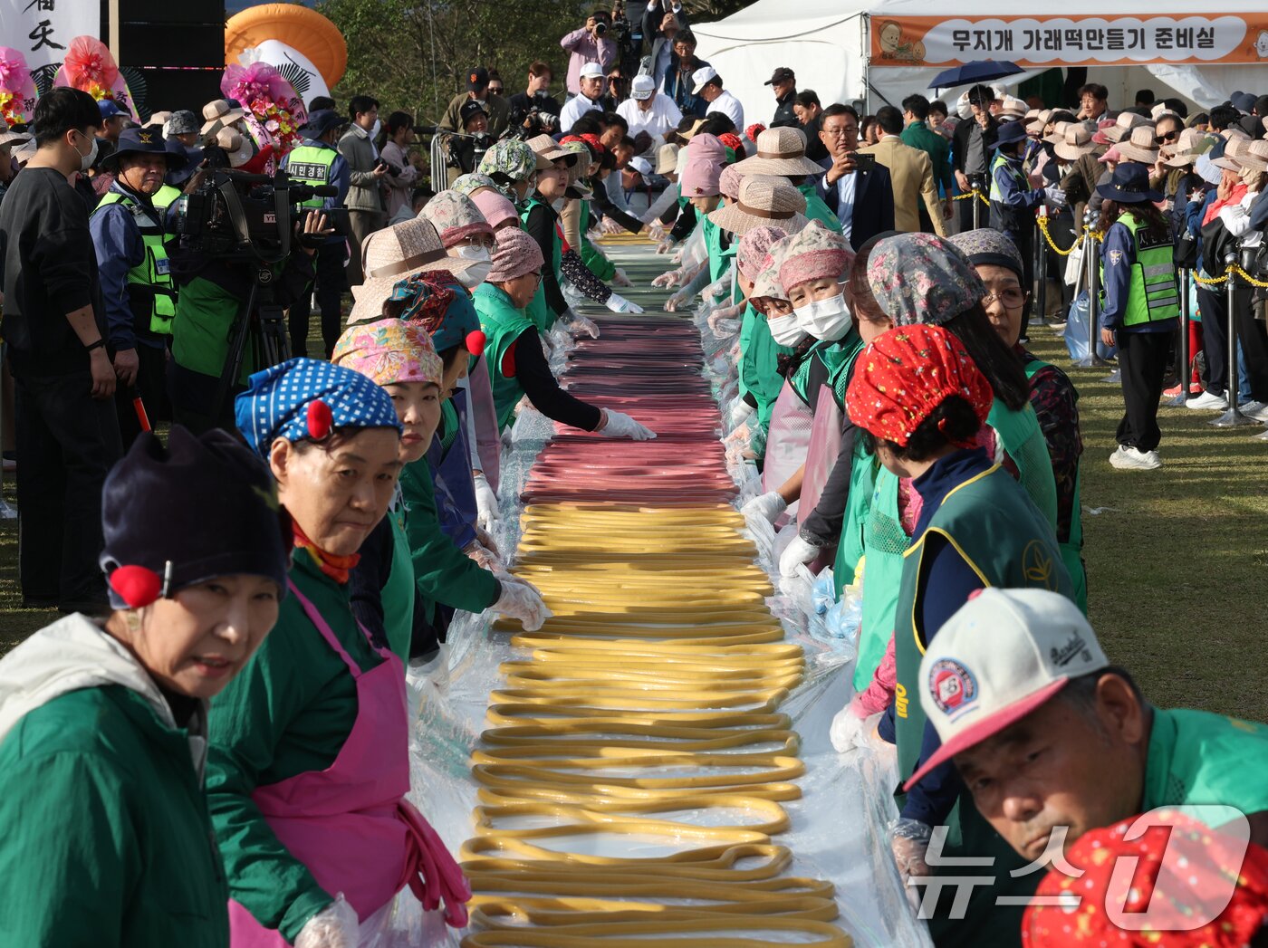 본문 이미지 - ‘제24회 이천쌀문화축제’가 개막한 22일 경기 이천시 모가면 이천농업테마공원에서 행사 관계자들이 600m 가래떡을 만들고 있다. 2025.10.22/뉴스1 ⓒ News1 김영운 기자