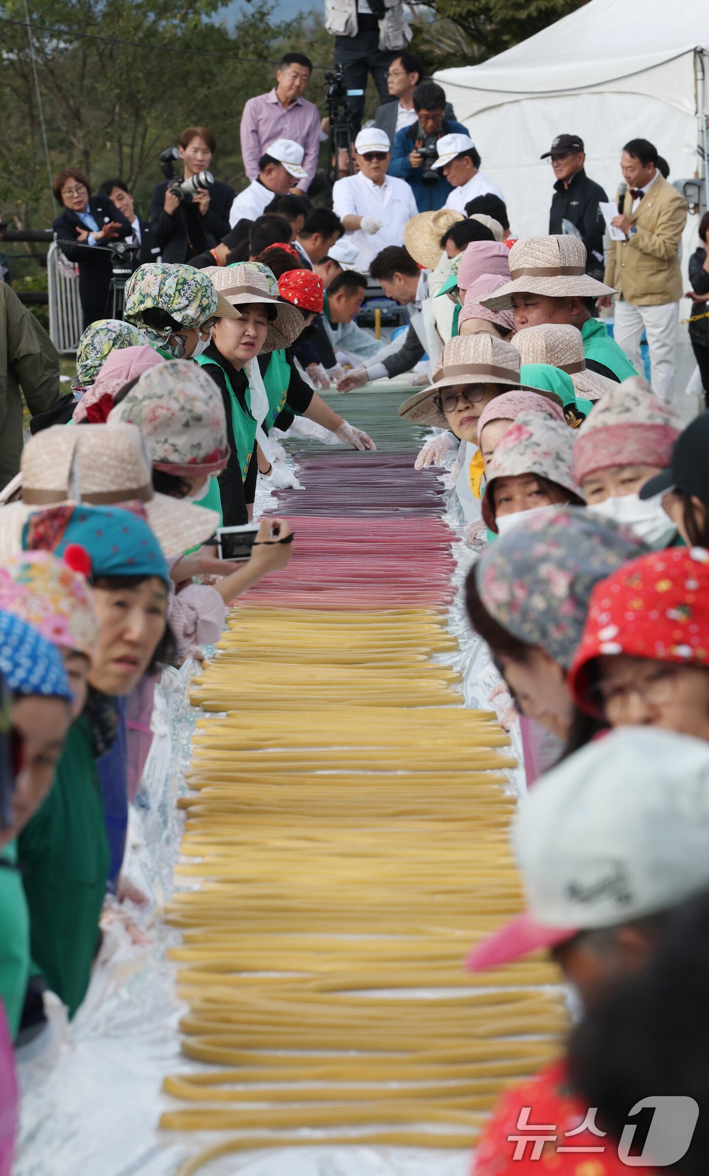 본문 이미지 - ‘제24회 이천쌀문화축제’가 개막한 22일 경기 이천시 모가면 이천농업테마공원에서 행사 관계자들이 600m 가래떡을 만들고 있다. 2025.10.22/뉴스1 ⓒ News1 김영운 기자