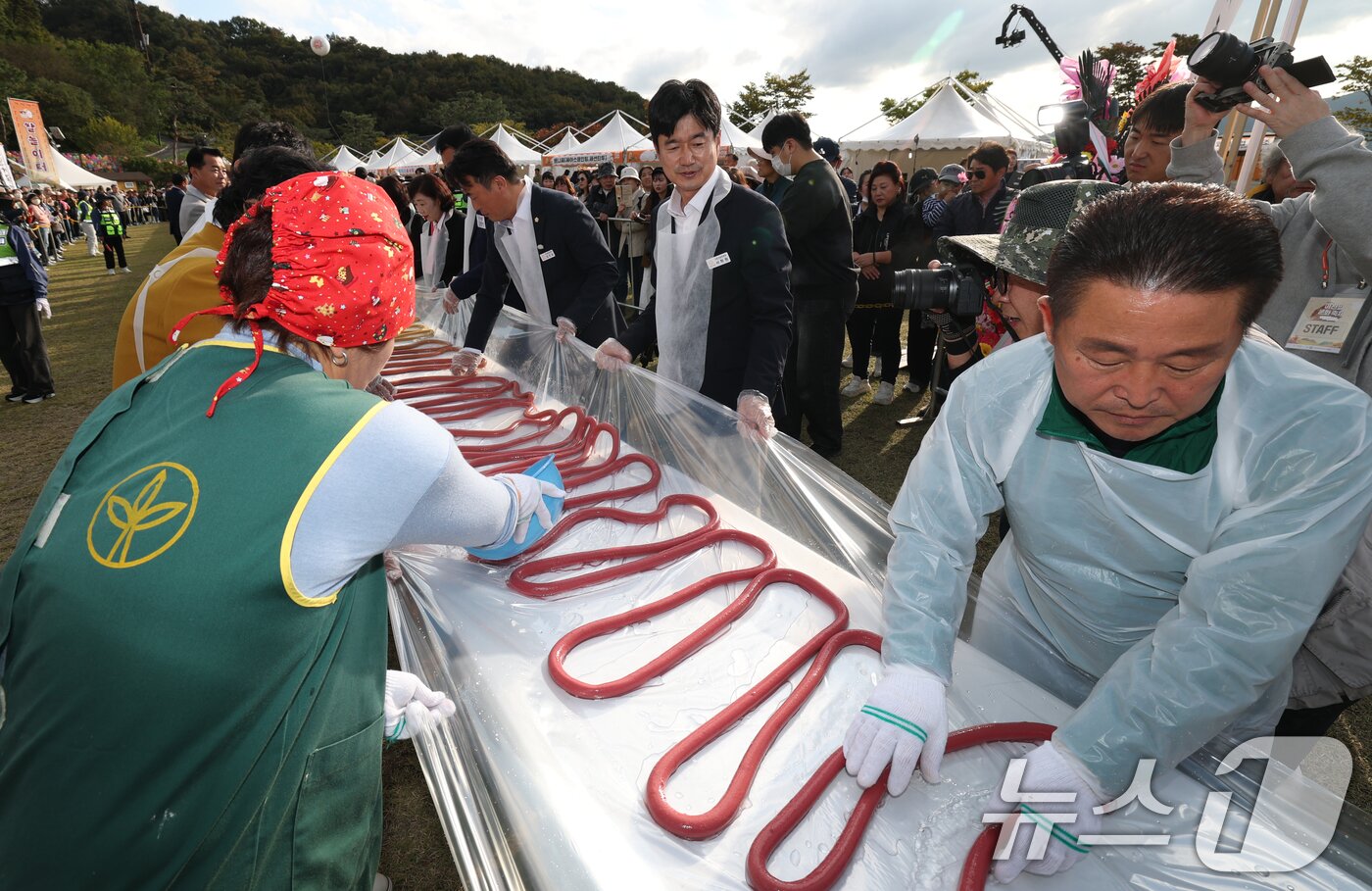 본문 이미지 - ‘제24회 이천쌀문화축제’가 개막한 22일 경기 이천시 모가면 이천농업테마공원에서 행사 관계자들이 600m 가래떡을 만들고 있다. ⓒ News1 김영운 기자
