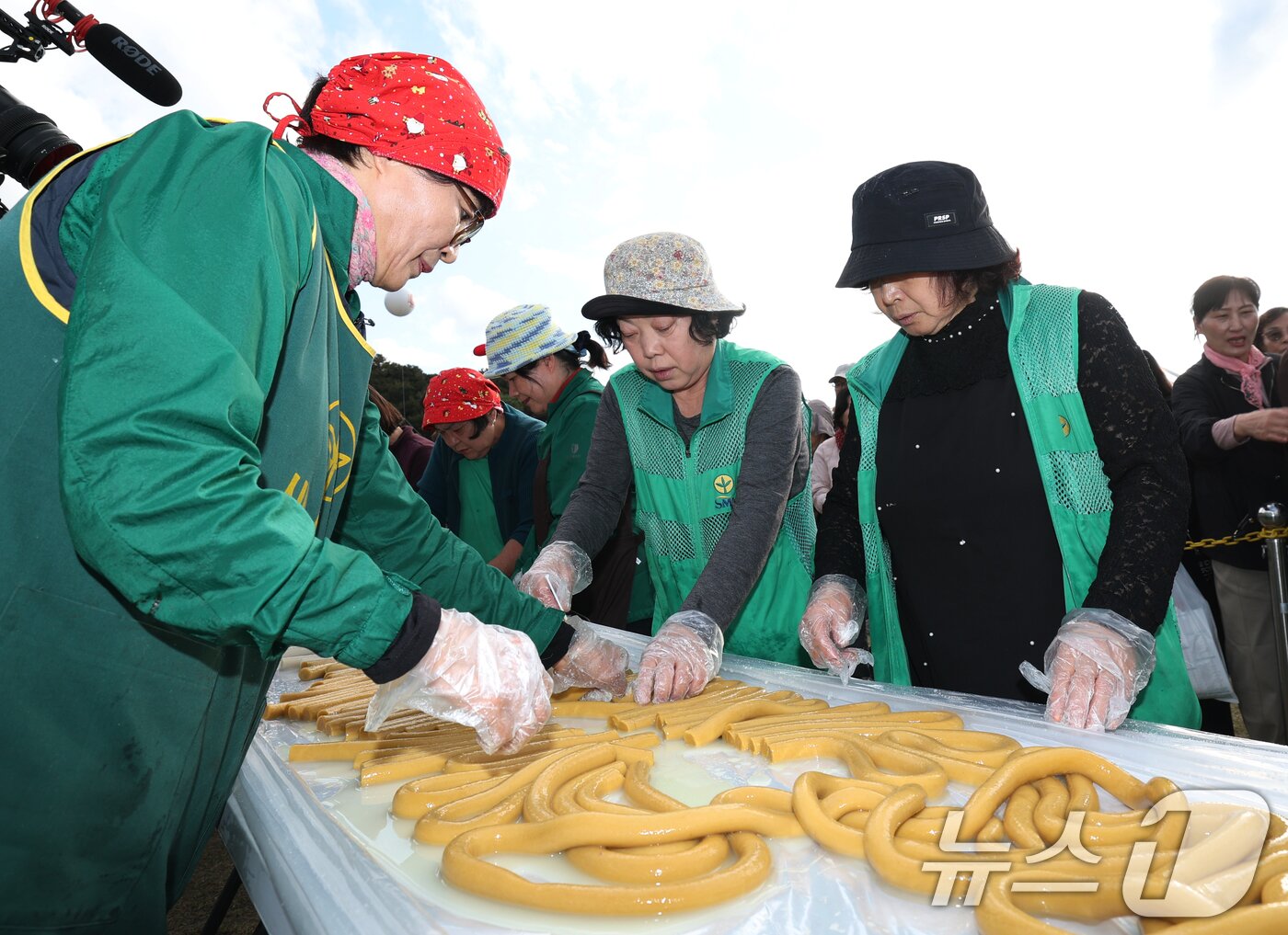 본문 이미지 - ‘제24회 이천쌀문화축제’가 개막한 22일 경기 이천시 모가면 이천농업테마공원에서 행사 관계자들이 600m 가래떡을 만들고 있다. ⓒ News1 김영운 기자