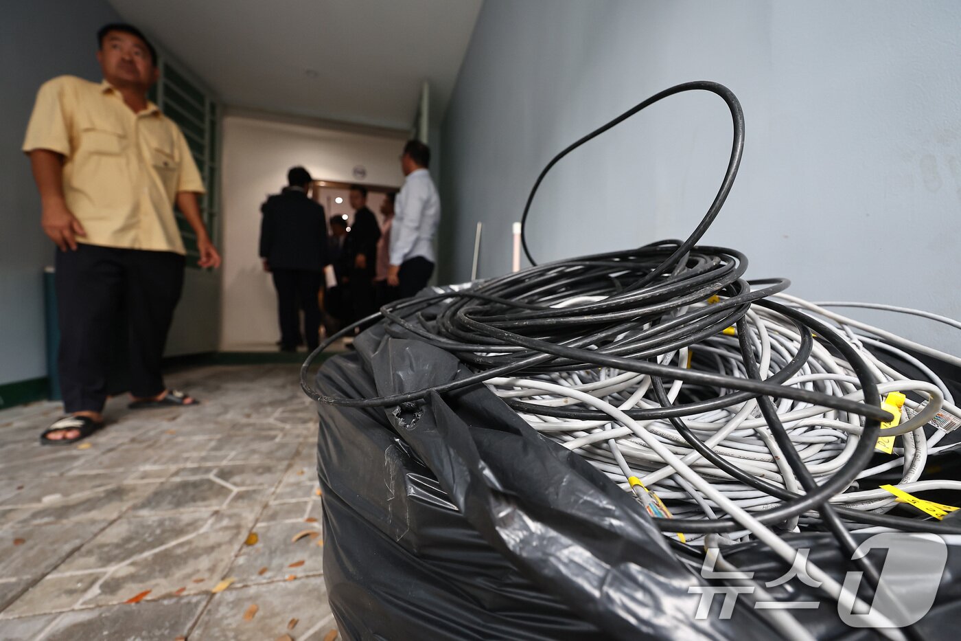 본문 이미지 - 22일&#40;현지시간&#41; 캄보디아 프놈펜 외곽 온라인스캠 범죄로 단속된 건물 내부에 인터넷 랜선이 남겨져 있다. 2025.10.22/뉴스1 ⓒ News1 김도우 기자