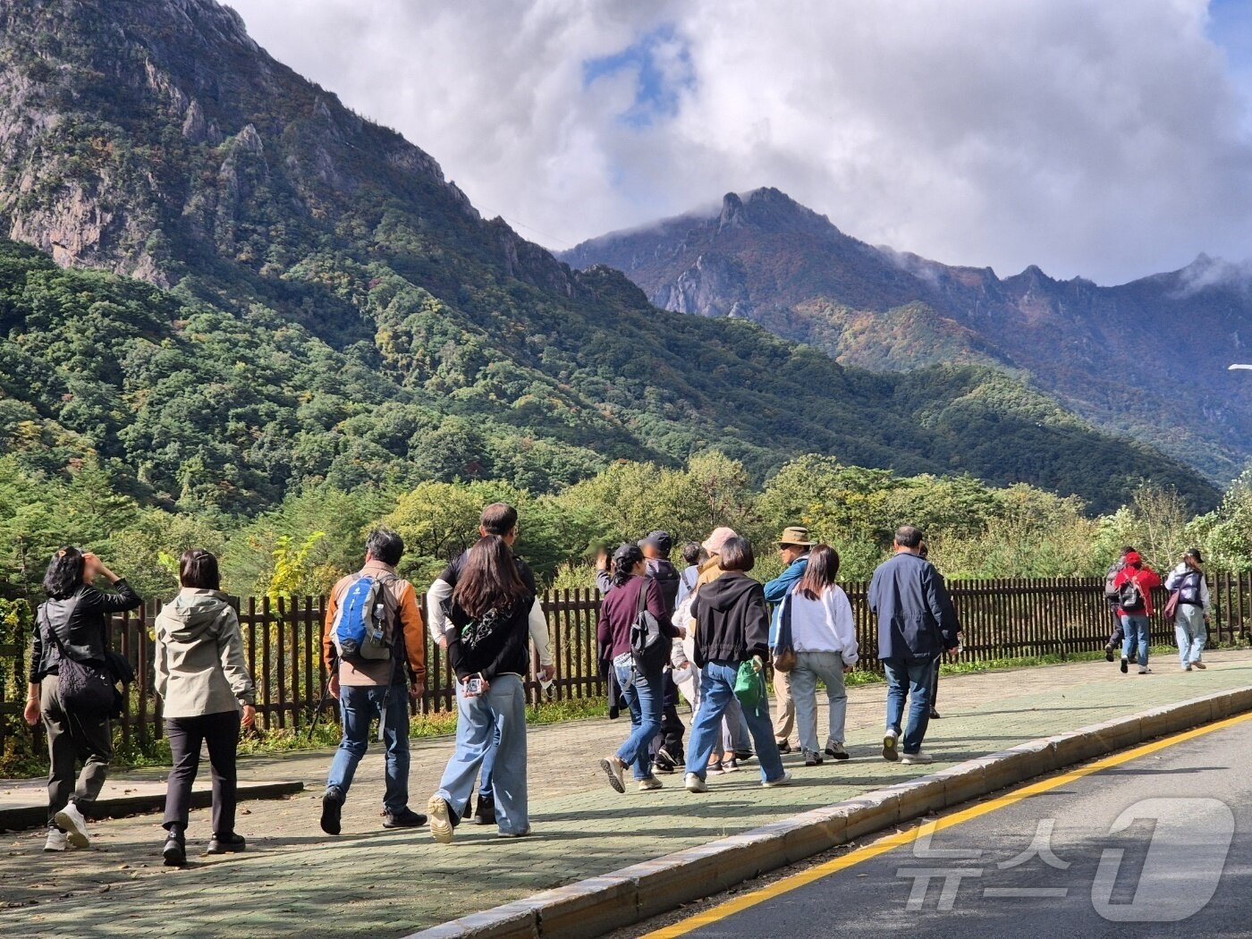 본문 이미지 - 23일 강원 속초시 설악산국립공원 입구에서 탐방객들이 줄지어 들어서며 절정의 단풍을 만끽하고 있다. 202510.23/뉴스1 2025.10.23/뉴스1 ⓒ News1 윤왕근 기자