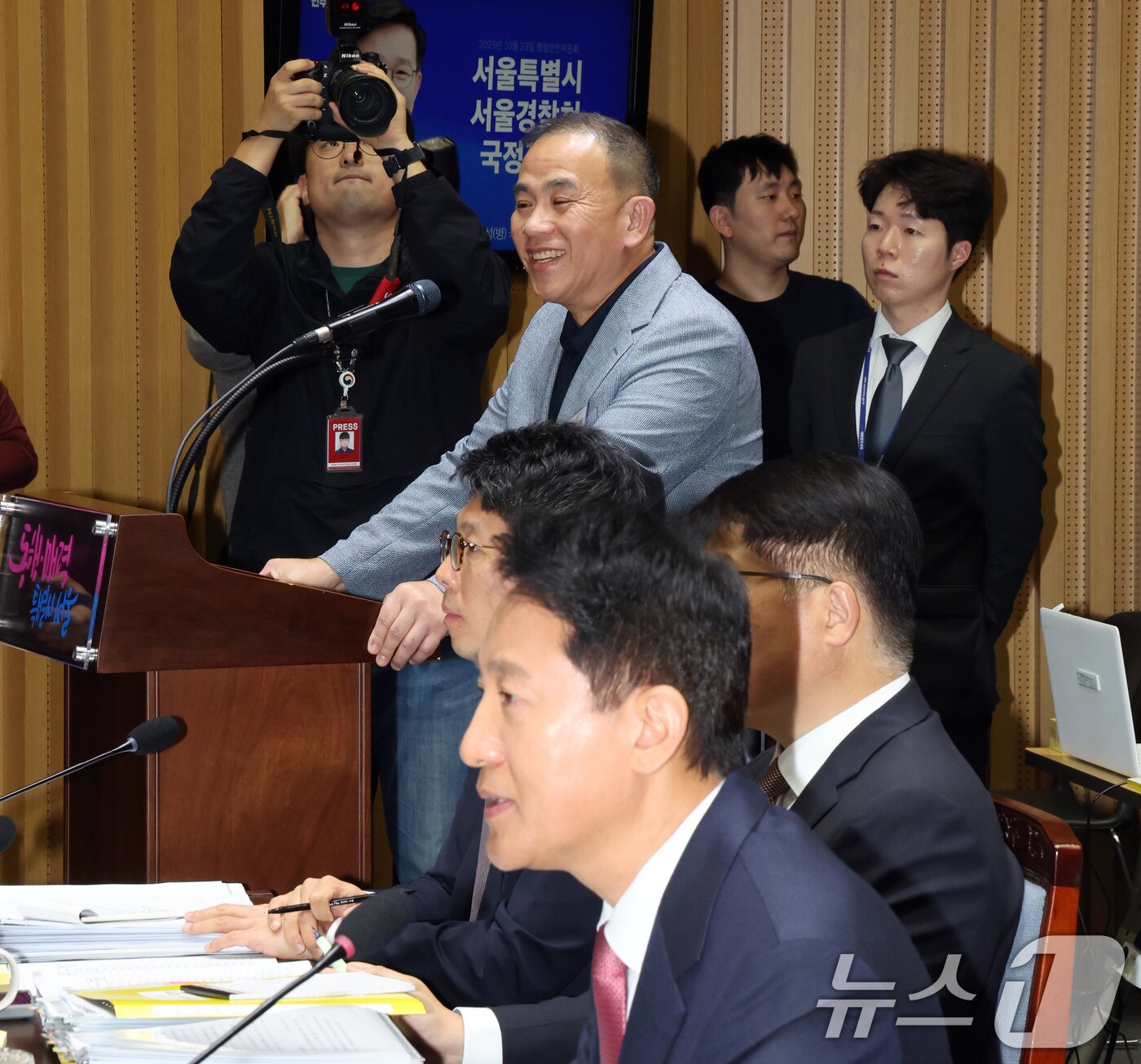 본문 이미지 - &#39;정치 브로커&#39; 명태균씨가 23일 오후 서울 중구 서울시청에서 열린 국회 행정안전위원회 서울시청 국정감사에서 오세훈 서울시장의 발언을 듣고 미소를 보이고 있다. 2025.10.23/뉴스1 ⓒ News1 황기선 기자