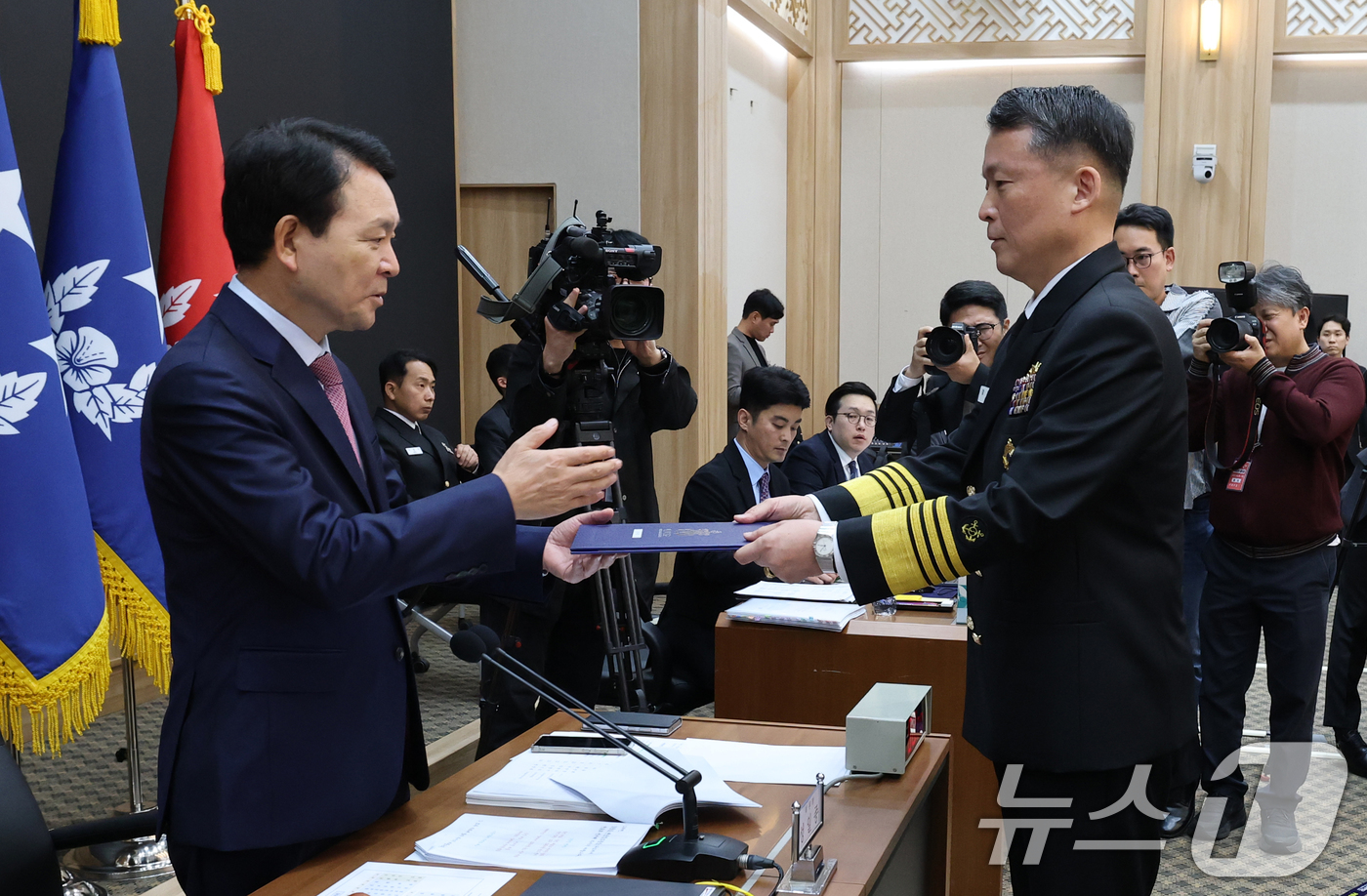 (계룡=뉴스1) 김기태 기자 = 강동길 해군 참모총장이 23일 충남 계룡대에서 열린 국회 국방위원회의 해군본부에 대한 국정감사에서 성일종 위원장에게 증인선서문을 전달하고 있다. 2 …